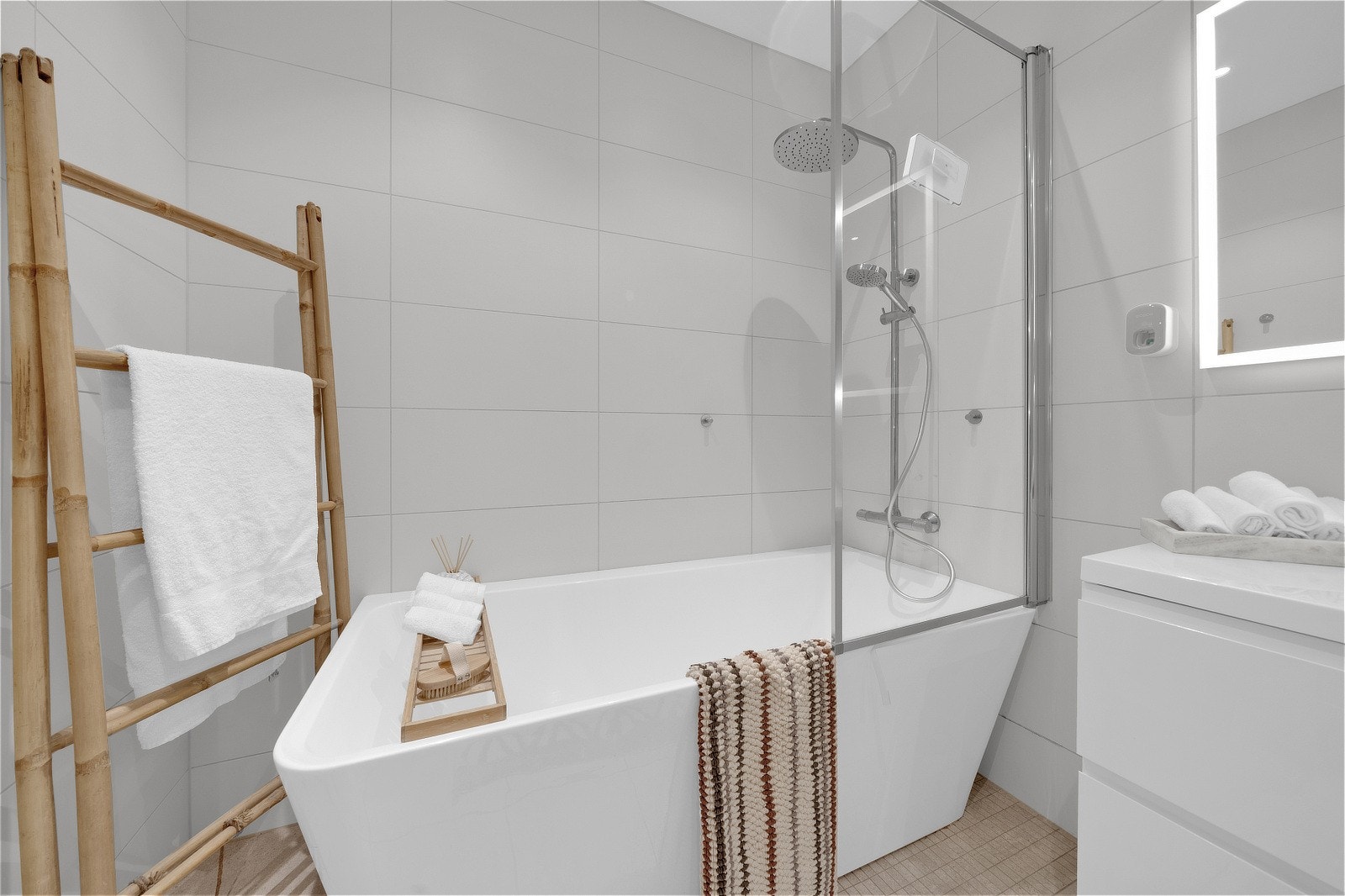 Dusjhjørnet er dekorert med pene små fliser, og badet har stor servant plassert på en skuffeseksjon med ettgrepskran. Galleribilde