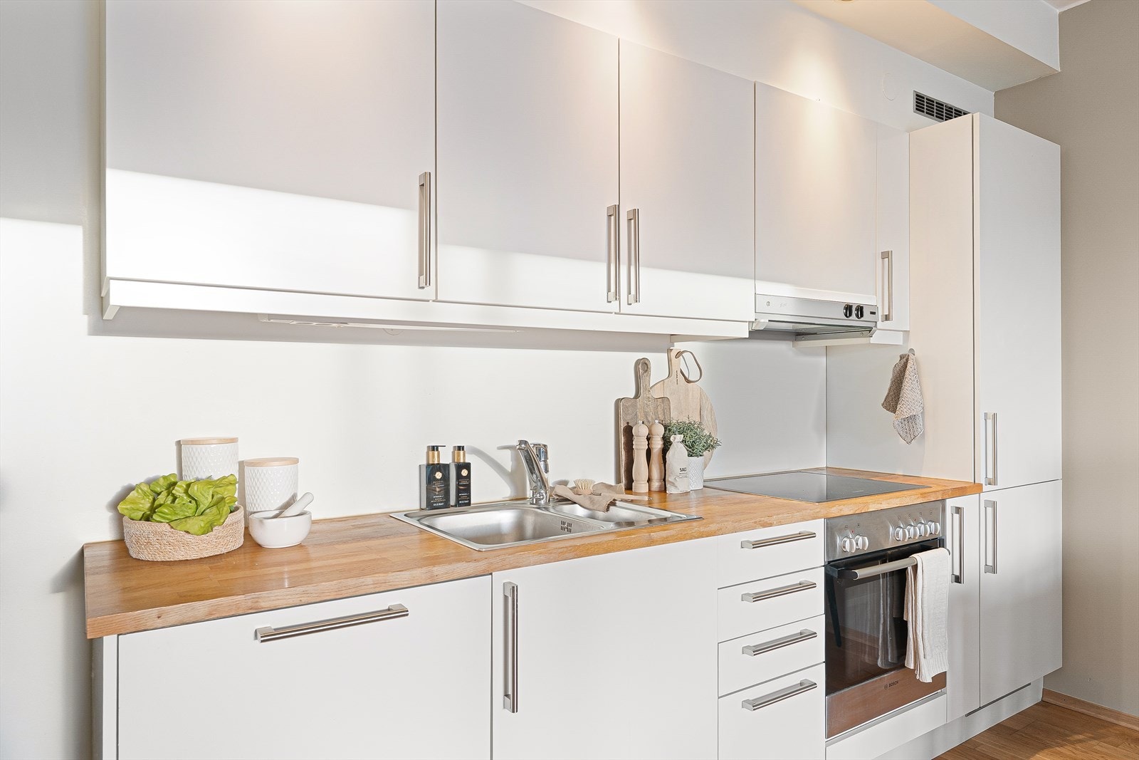 Kjøkkenet har godt med oppbevaringsplass i over- og underskap, samt benkeplate for gunstige arbeidssoner. Det er videre innredet med mekanisk avtrekksvifte over stekesone. Galleribilde