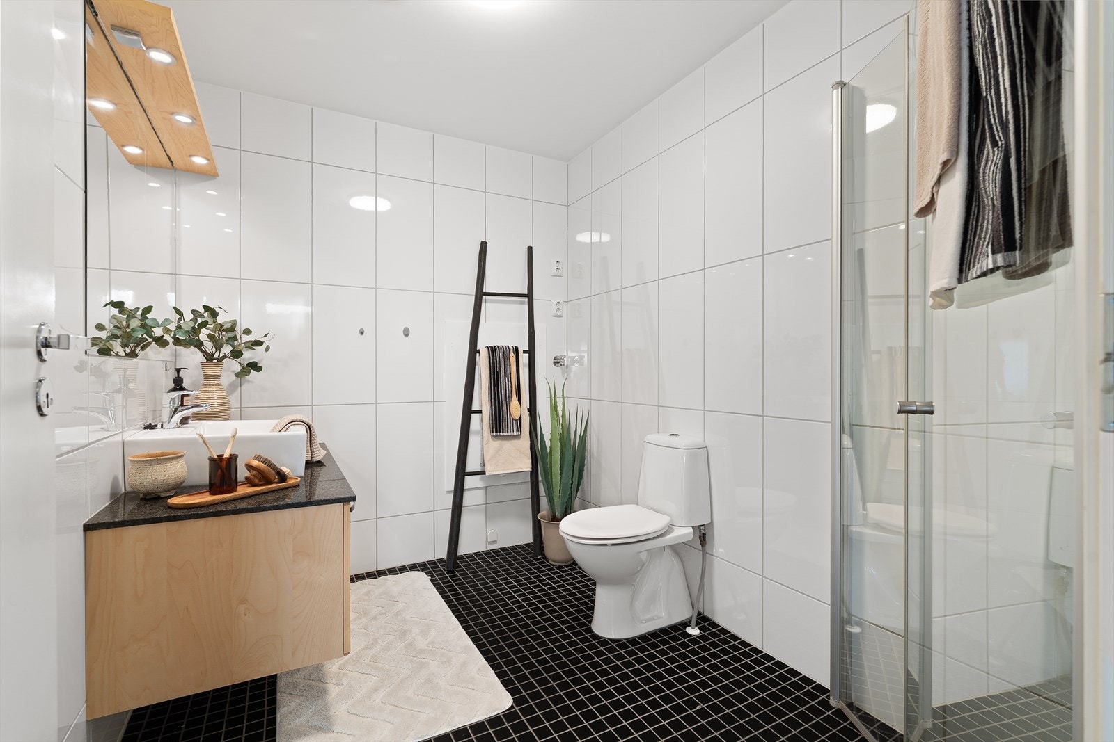 Baderommet er på 5,5 m², og er flislagt fra topp til tå med varme i gulv og moderne downlights over speil for en moderne lyssetting. Baderomsinnredningen er levert av HTH og har god plass til lagring av både håndduker og øvrige baderomsartikler. Galleribilde