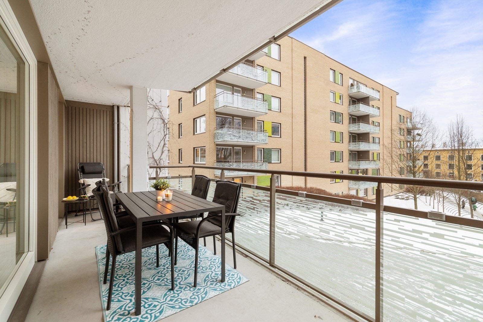 På sommeren er det frodig beplanting med trær, busker og klatreplanter som omringer leiligheten. Galleribilde