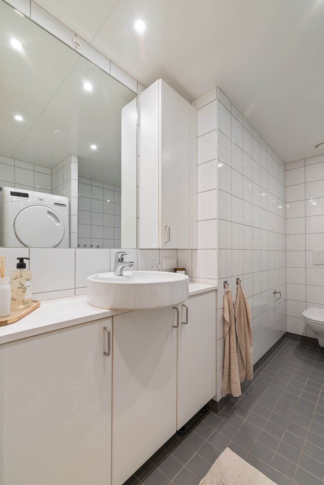 Lys og tidløst flislagt bad med varmekabler i gulv. Galleribilde