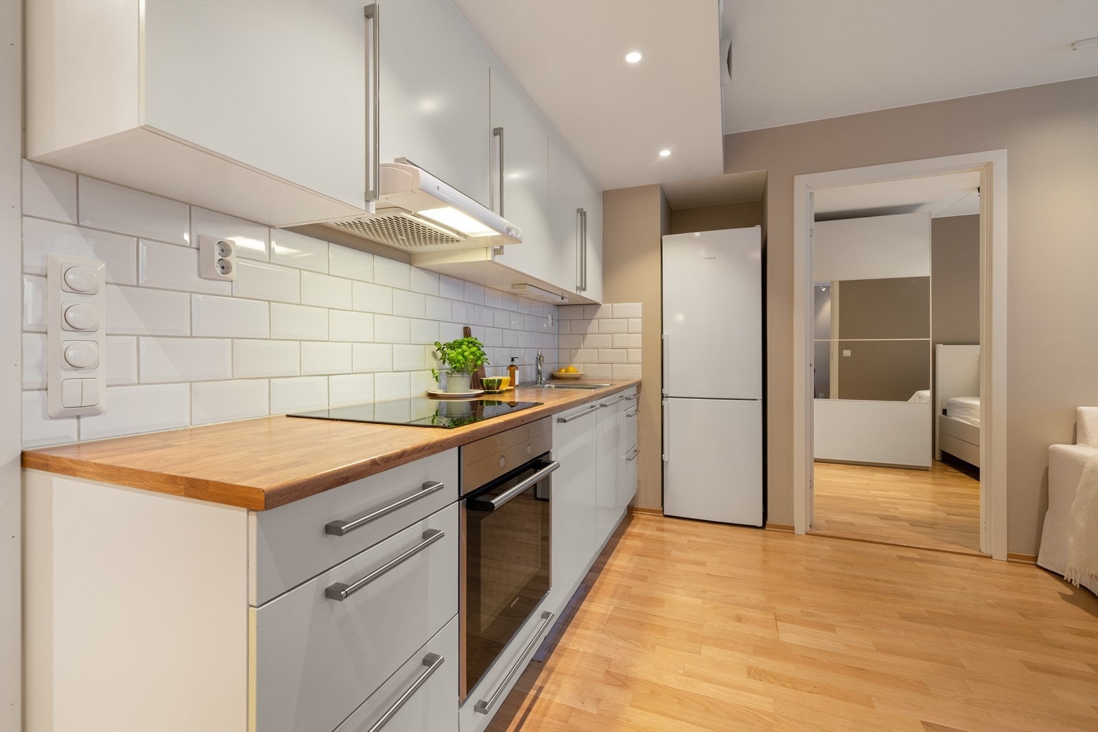 Frittstående kjøleskap er pent tilbaketrukket i nisje. Galleribilde