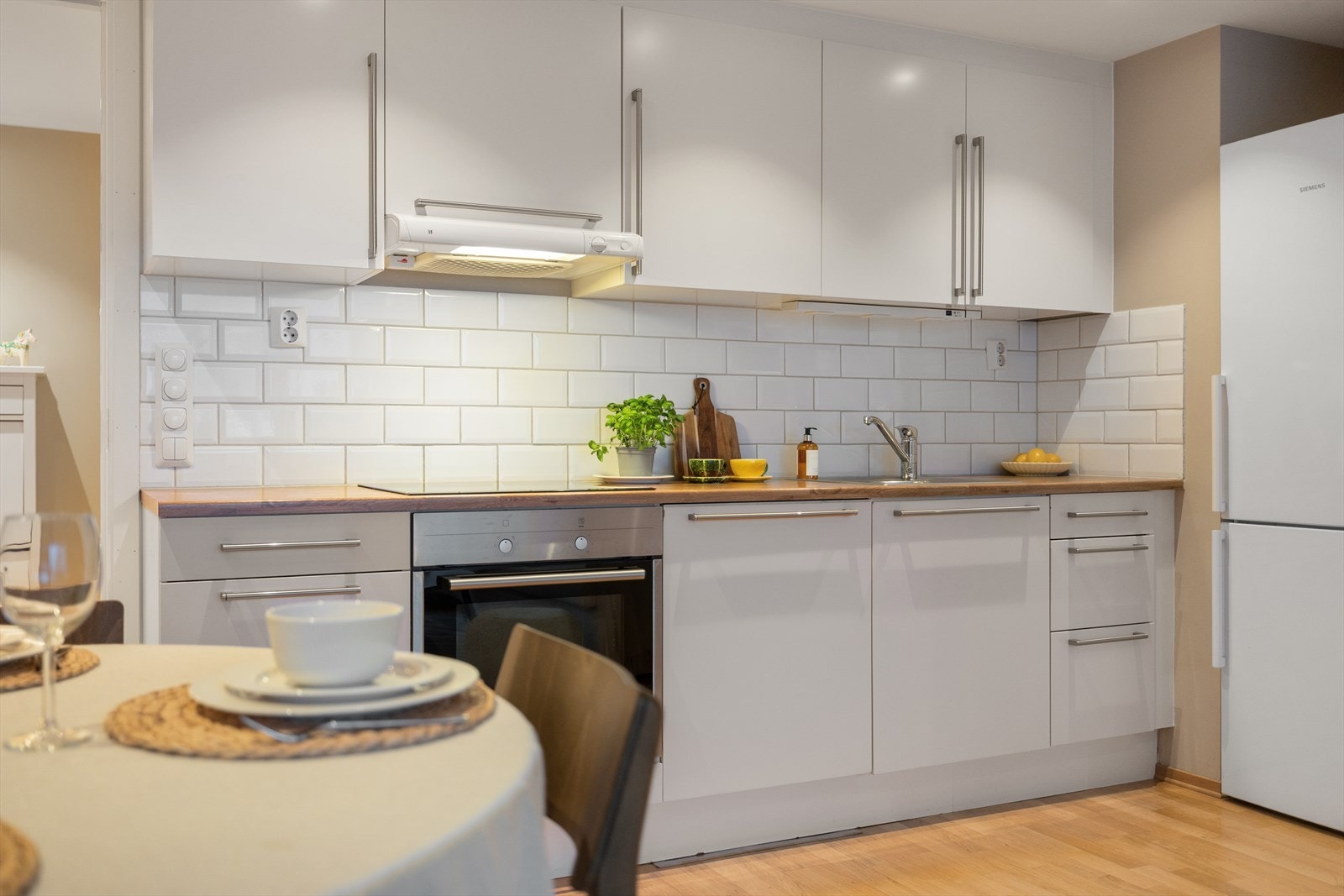 Integrerte hvitevarer som oppvaskmaskin, stekeovn og koketopp. Det er lekre flis mellom benkeplate og overskap. Galleribilde