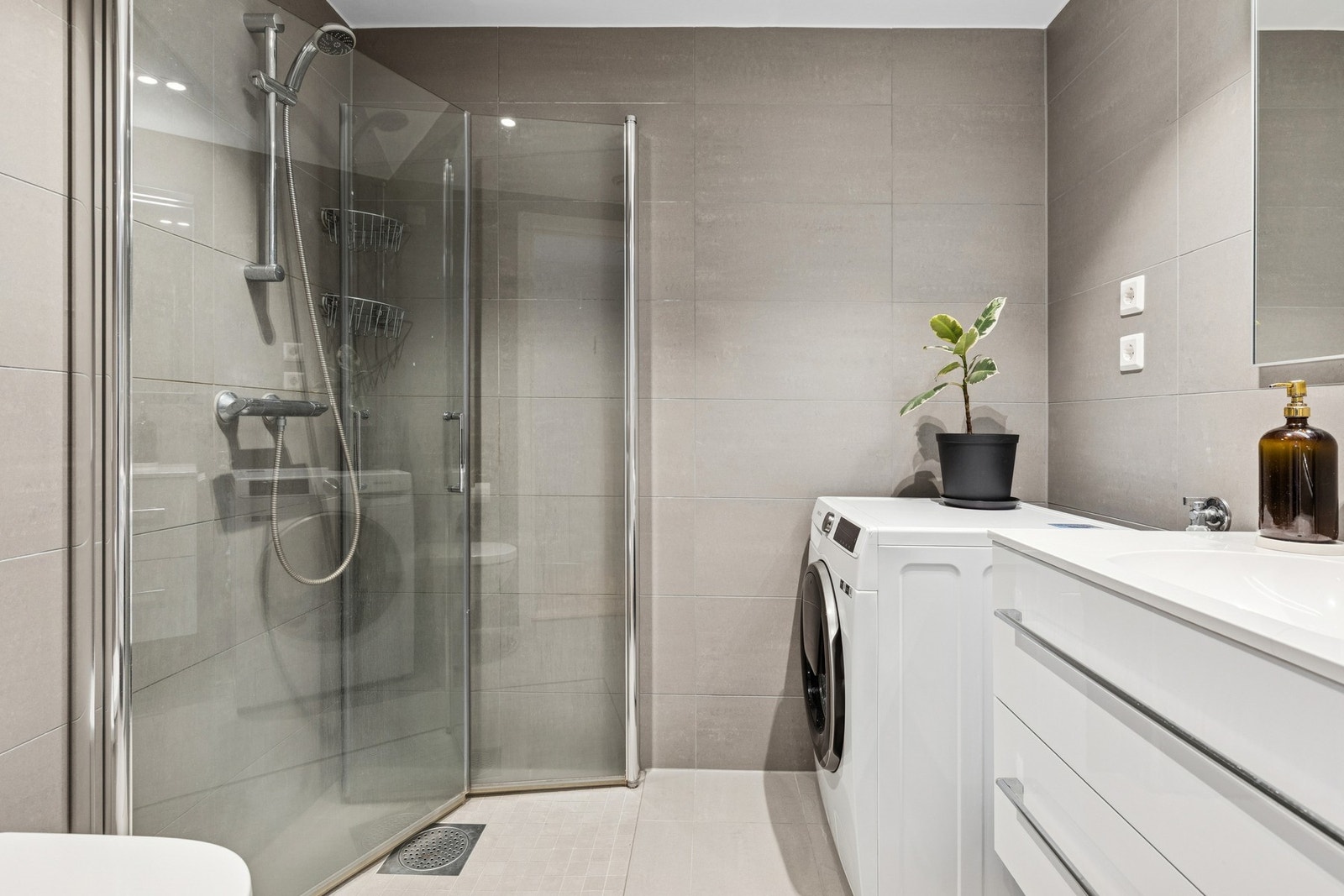 Badet er fra 2020 og har lyse fliser på gulv og vegger. Galleribilde