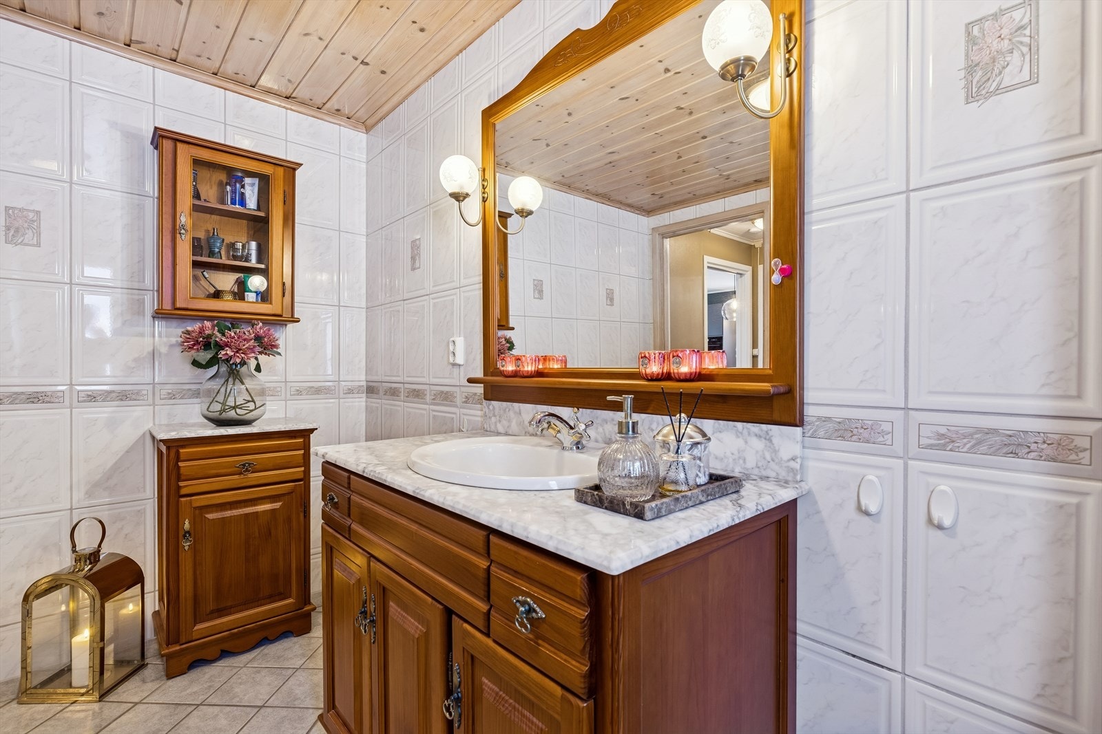 Badet er stilfullt innredet med vegghengt toalett, marmorplate med nedfelt porselen servant og underskap og dusjkabinett med glassdører. Galleribilde