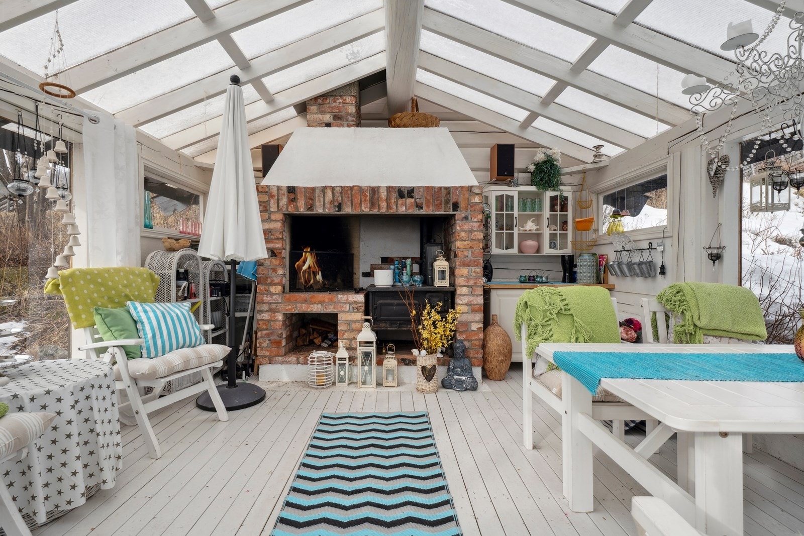 Lysthuset har peis, vedovn og plass til flere sittegrupper Galleribilde