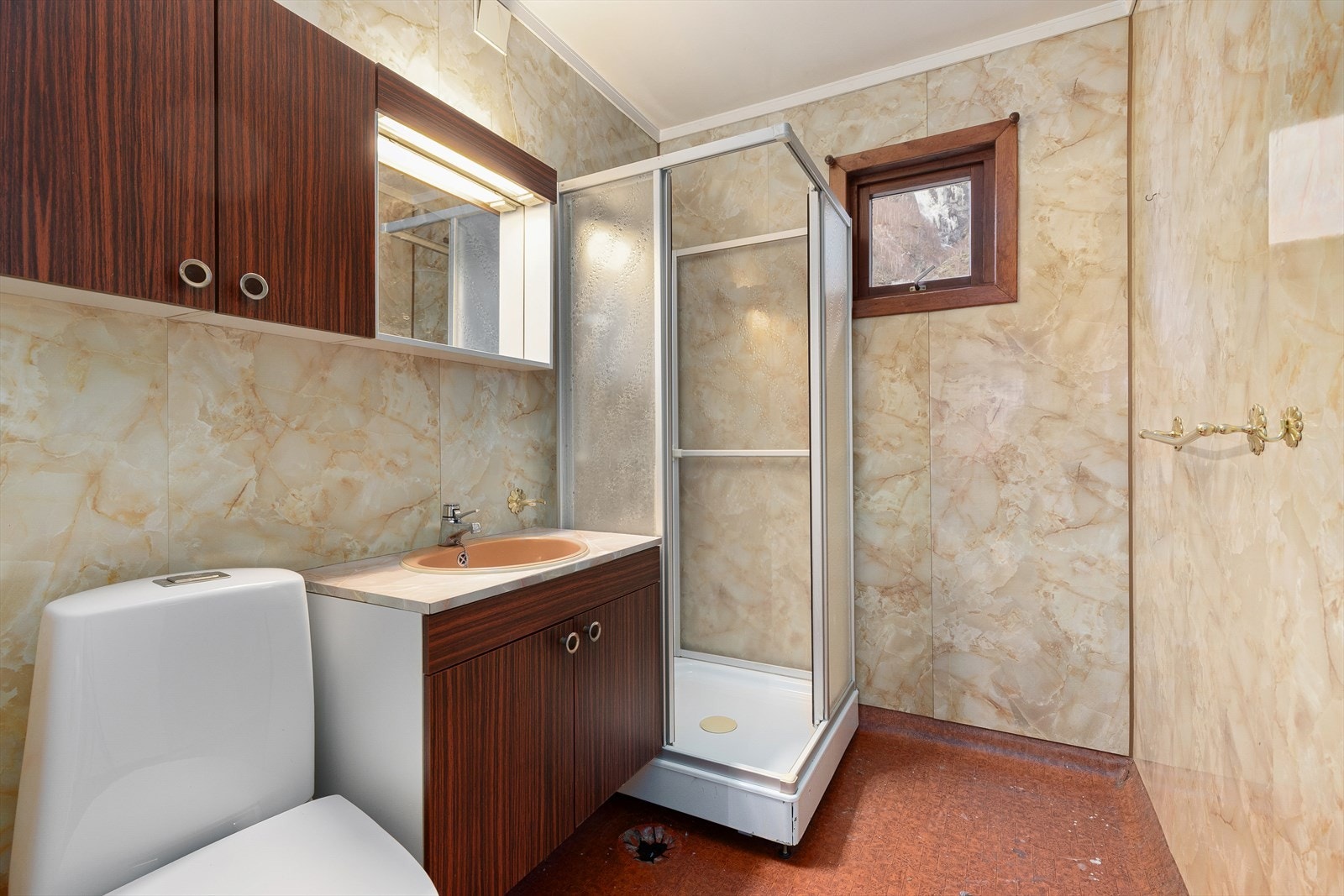 Enkelt eldre bad modent for oppussing. Badet gir plass til dusjhjørne, toalett og servant med innredning. Galleribilde