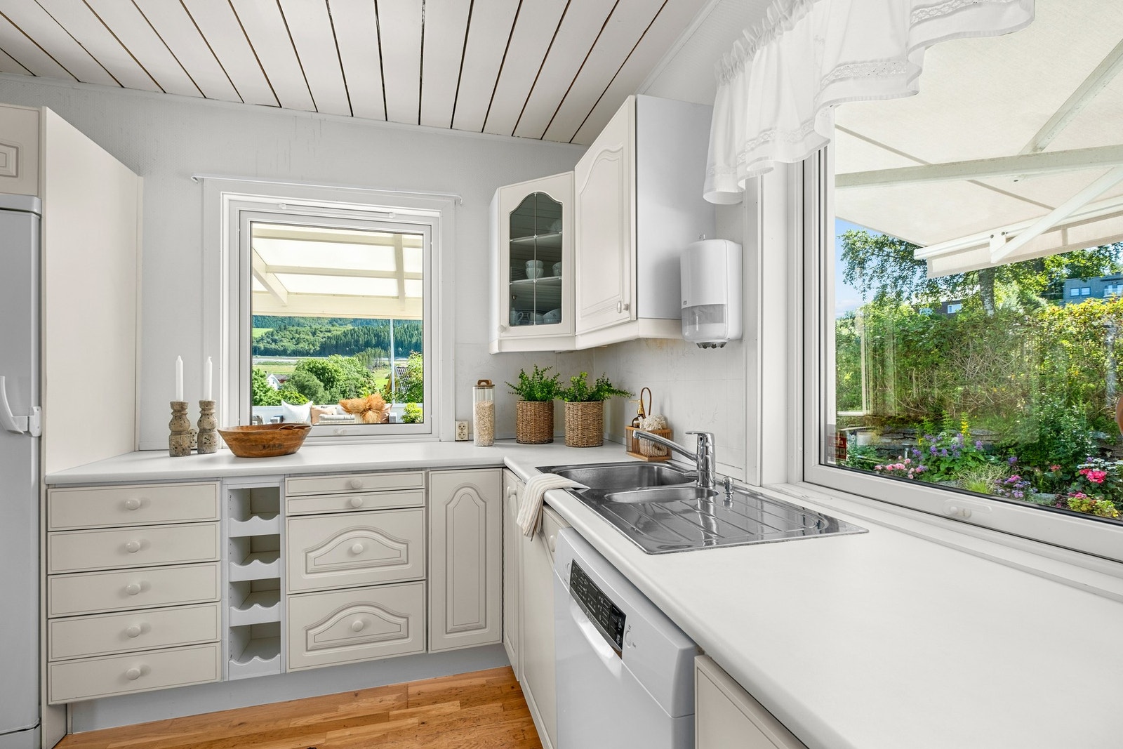 På kjøkkenet strømmer lyset inn gjennom vinduer over benkeplaten på begge sider, noe som gir et lyst og behagelig arbeidsrom. Galleribilde