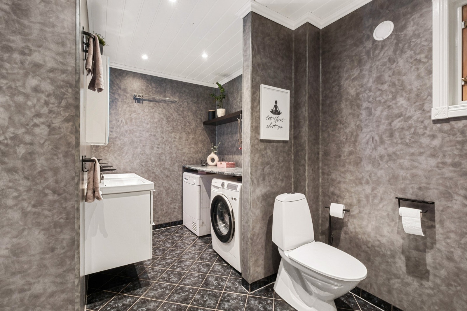 Badet har innredning med 2 nedfelte servanter, gulvstående toalett, badekar og opplegg for vaskemaskin. Galleribilde