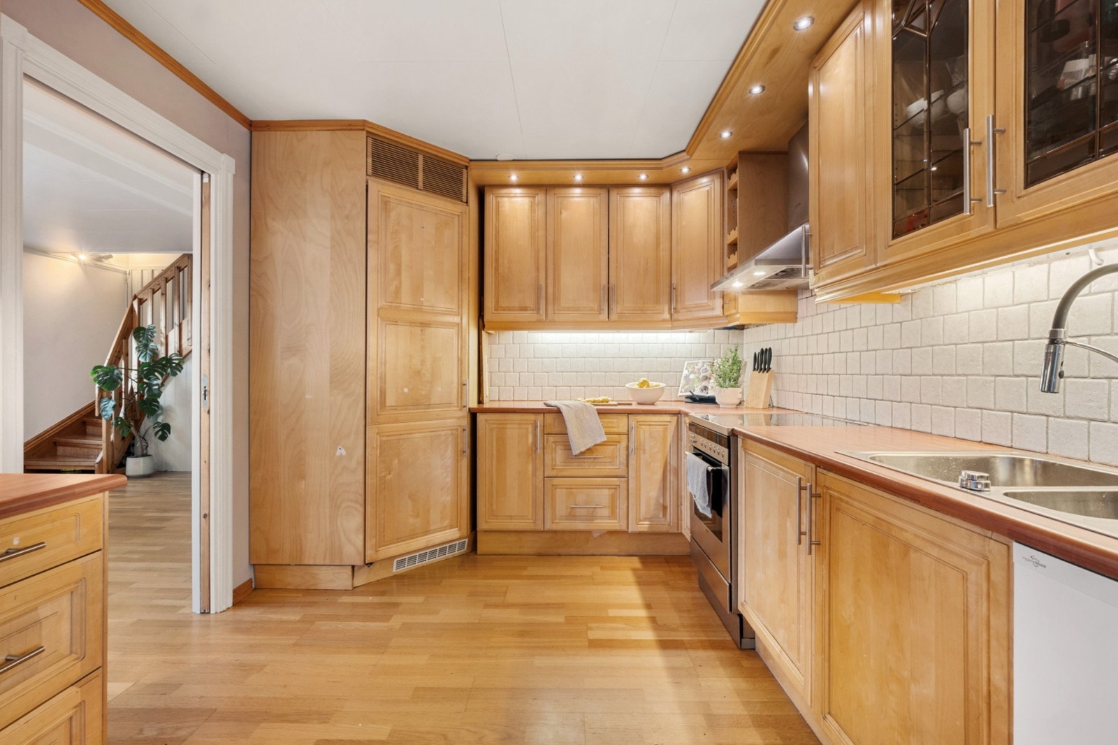 Kjøkkenet har fronter i profilert eik og fliser montert under overskap. Galleribilde