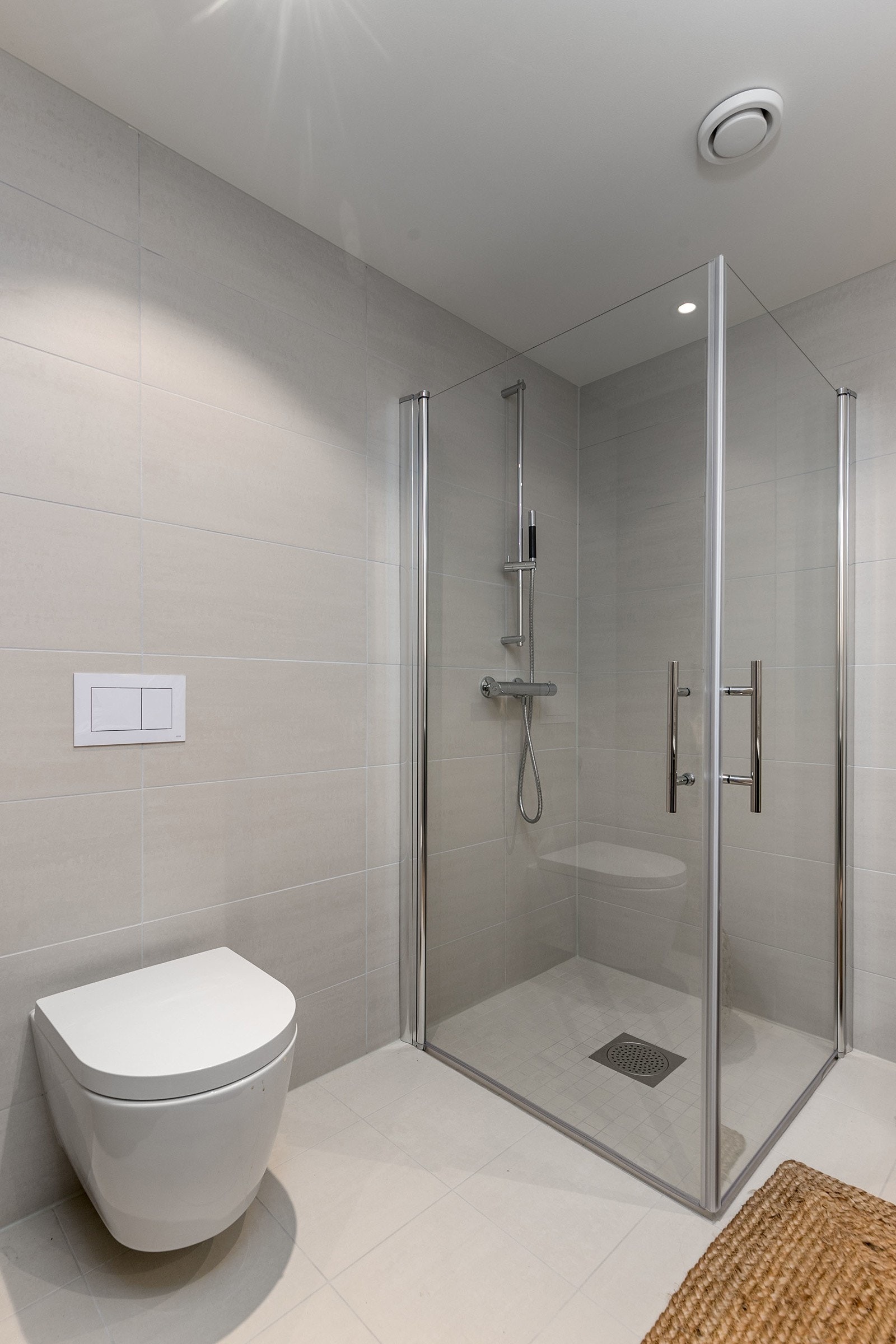 Dusjsone med innfellbare dører og vegghengt toalett Galleribilde