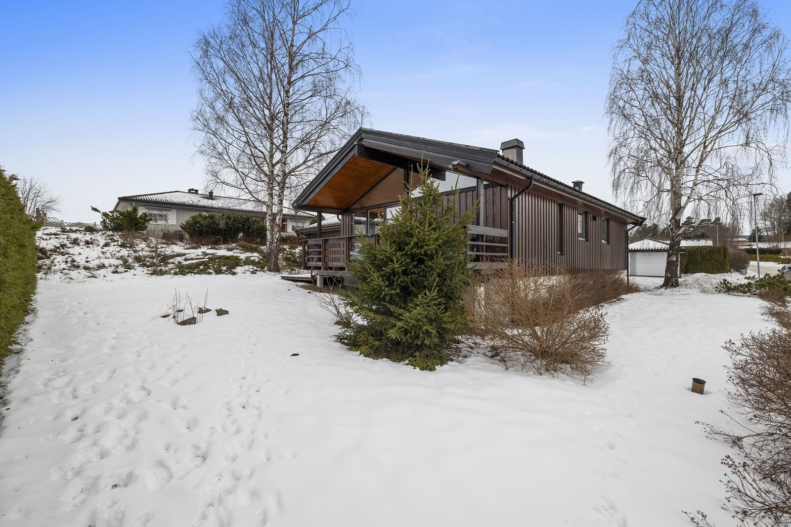 Tomten er rikt beplantet med diverse prydbusker, prydtrær og blomsterbed, samt mye naturlig vegetasjon Galleribilde