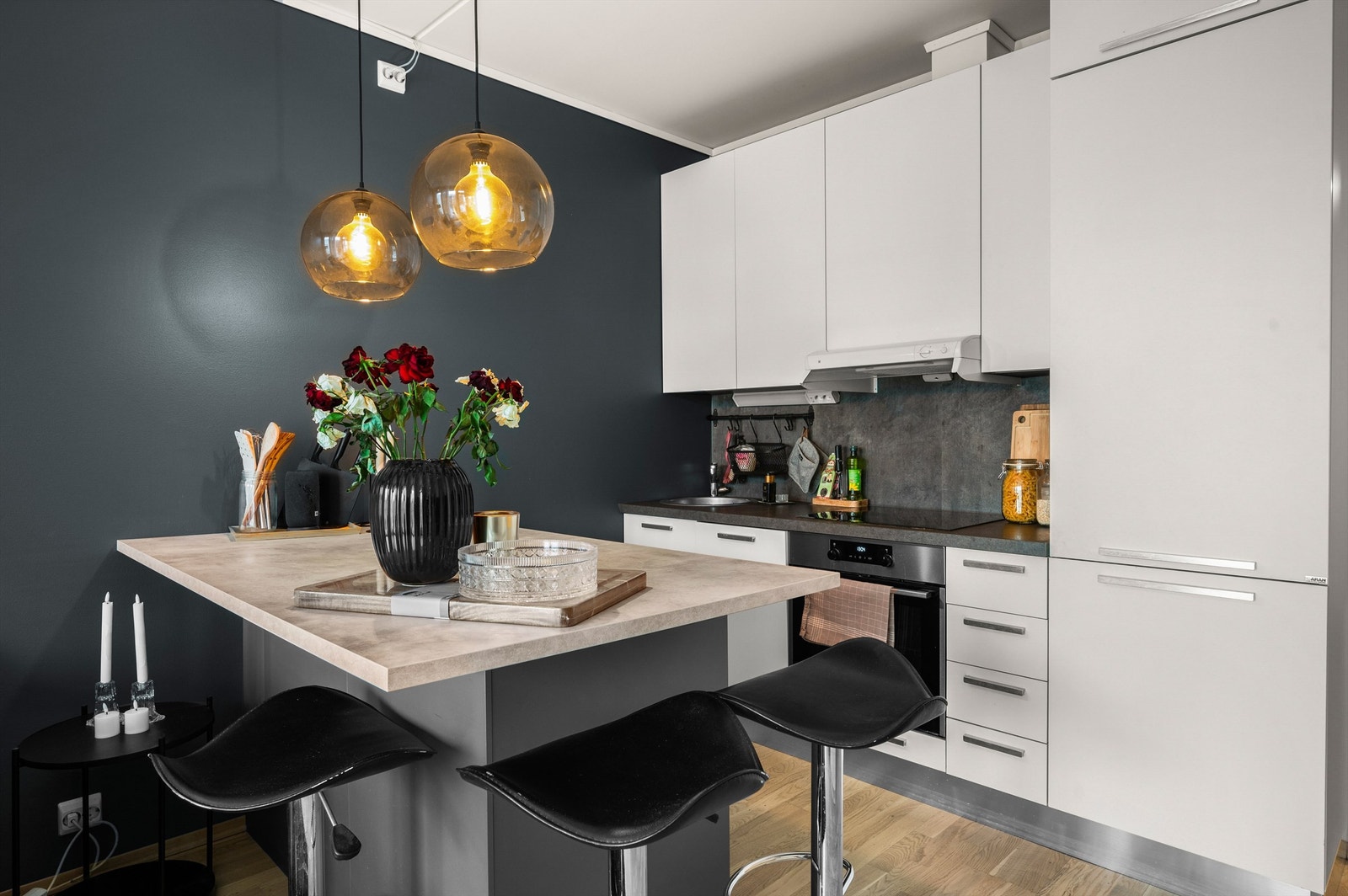 Tidsriktig kjøkkeninnredning fra Aran med lyse slette flater, benkeplate i kontrast samt integrert stekeovn, platetopp, oppvaskmaskin og kjøleskap med fryser. Galleribilde