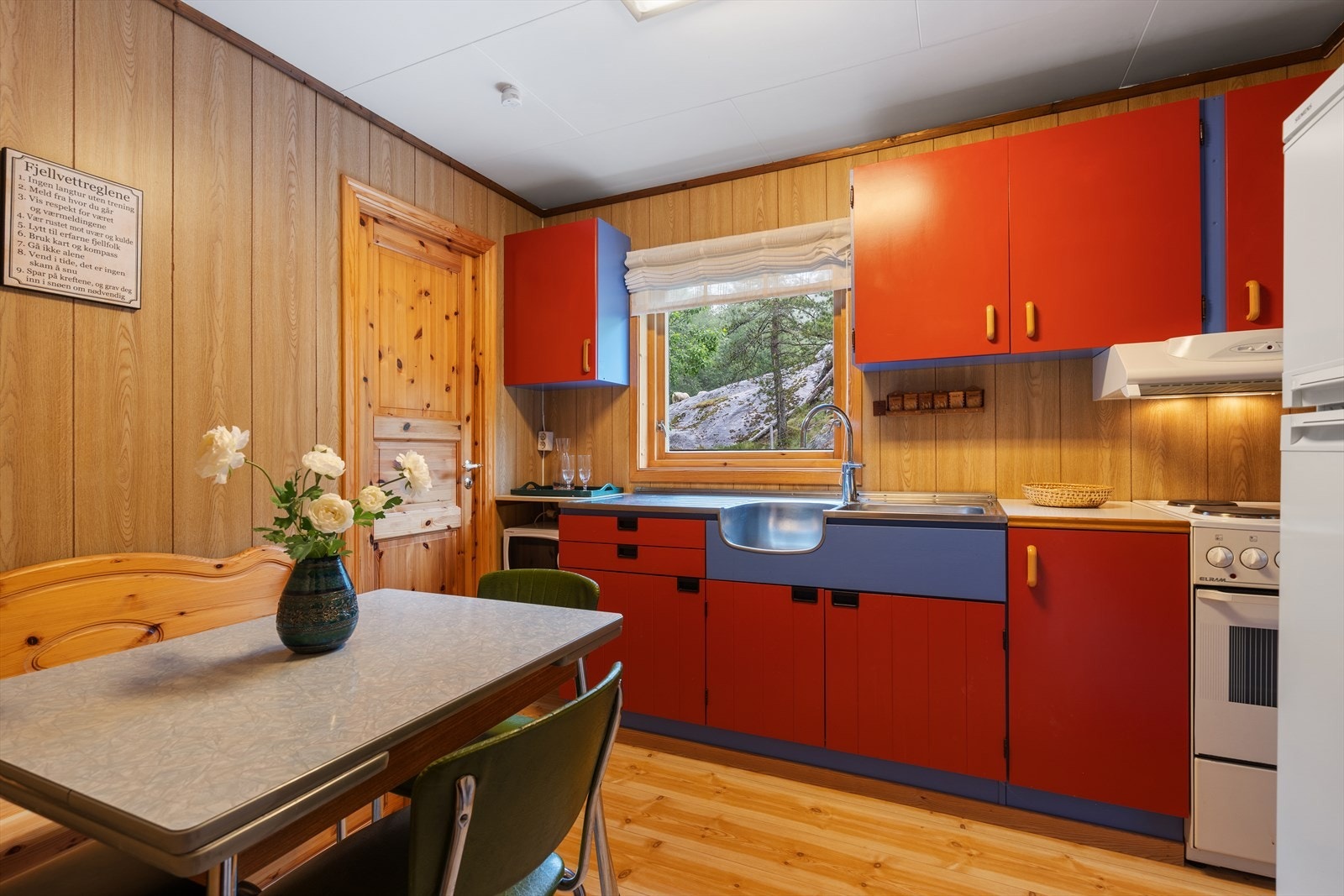 Kjøkkenet er innredet i nostalgisk stil med fargerike fronter og spiseplass. Galleribilde
