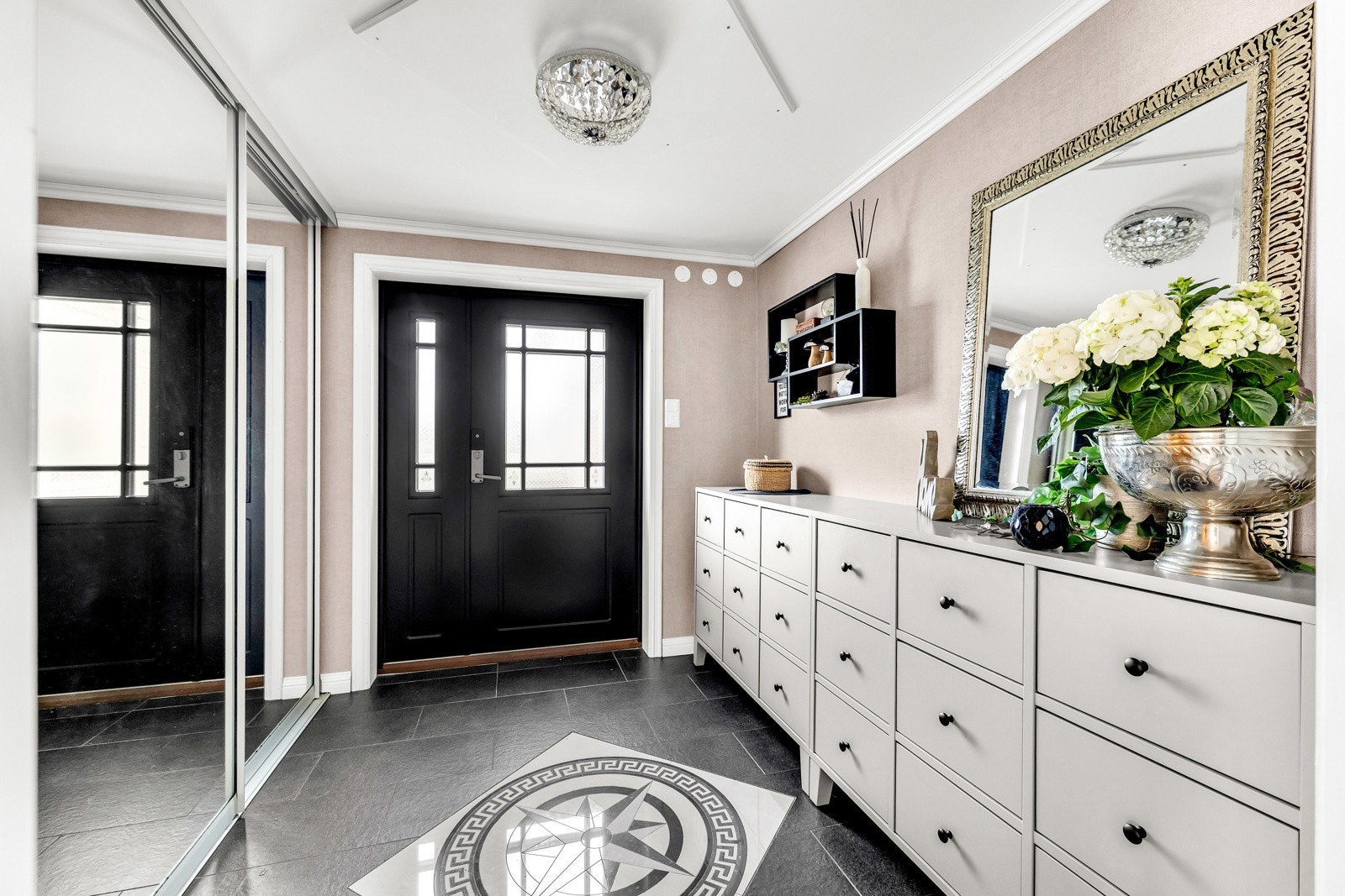 Inn i boligen ønskes du velkommen av en romslig og innbydende entré med flislagt gulv og tapetserte vegger. Galleribilde