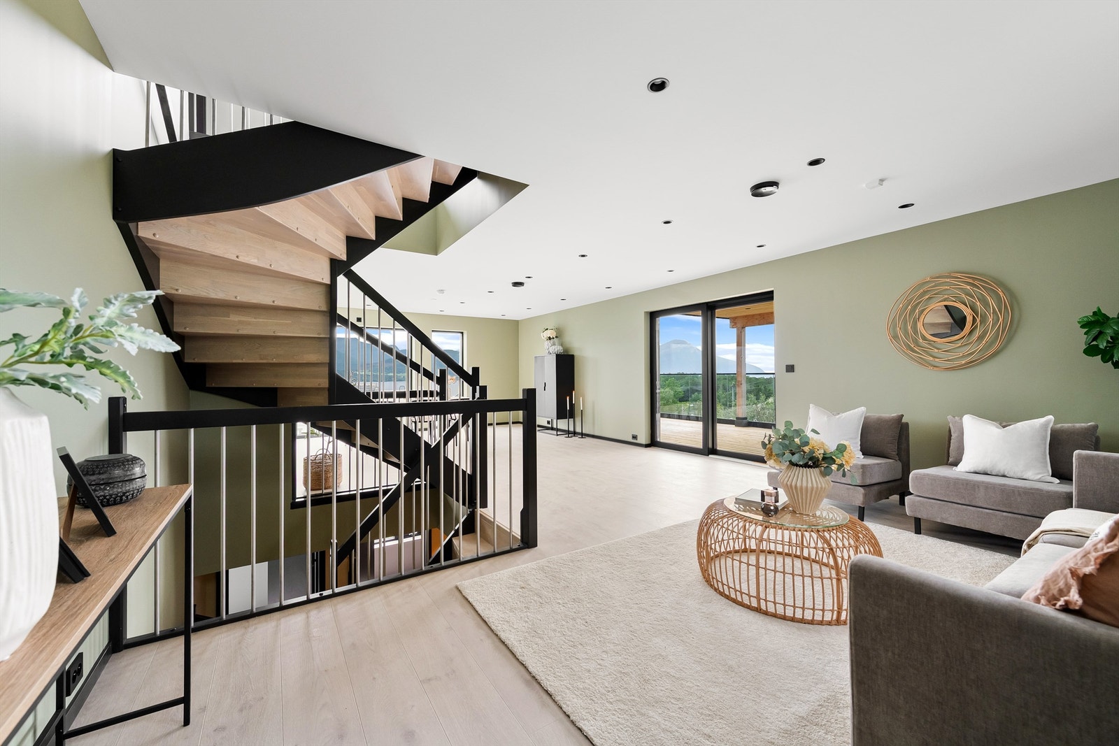 Flott trapp i tre mellom etasjene med rekkverk i tre og stål. Spotter i tak Galleribilde