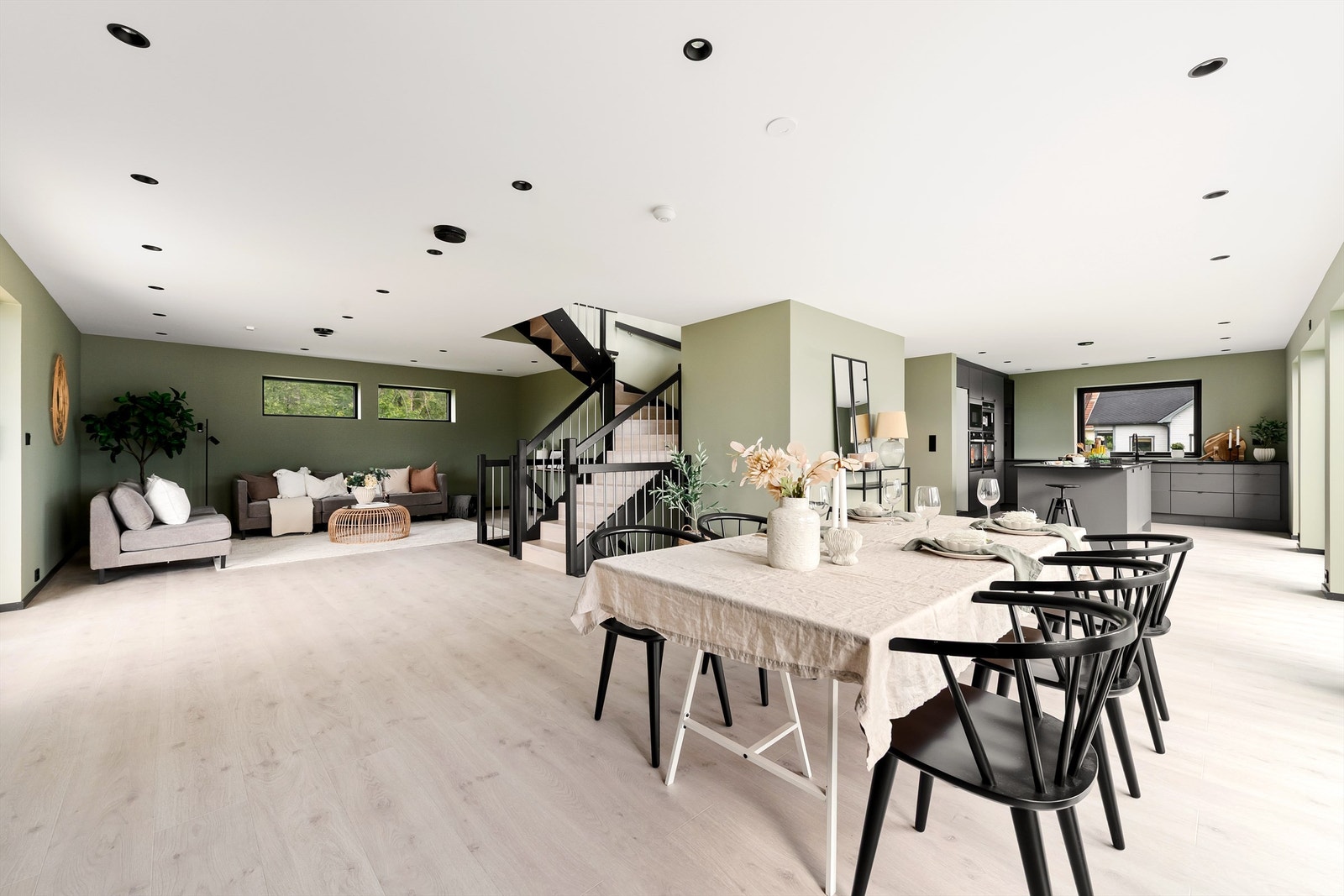 Stor romslig stue/spisestue og kjøkken i åpen løsning med god plass til flere soner Galleribilde