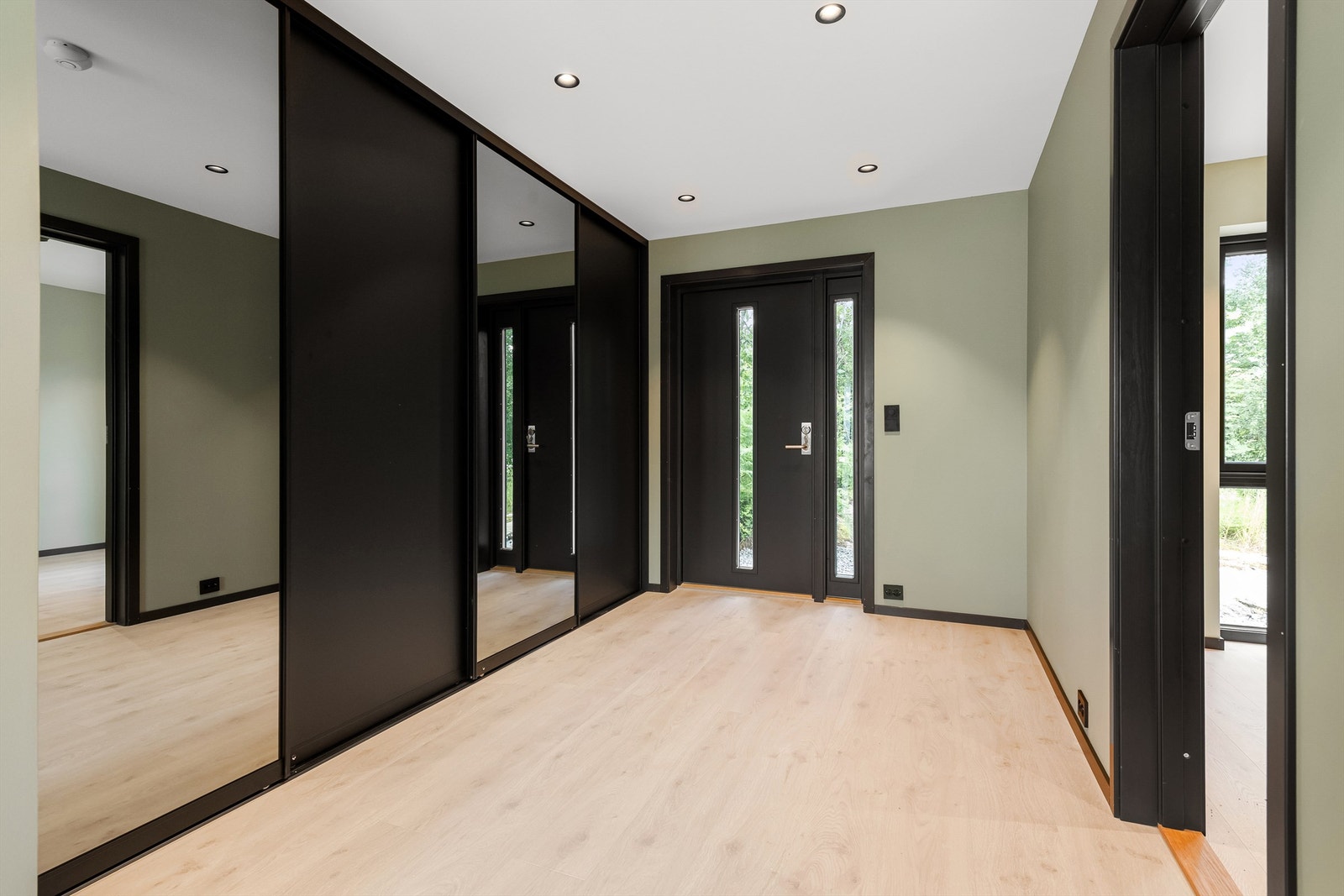 Entre/inngangsparti i 1. etasje med stor skyvedørsgarderobe Galleribilde