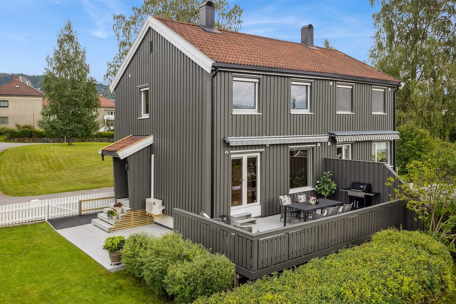 Tomten er inngjeredet og pent opparbeidet med plen, hekker og diverse beplantning Galleribilde