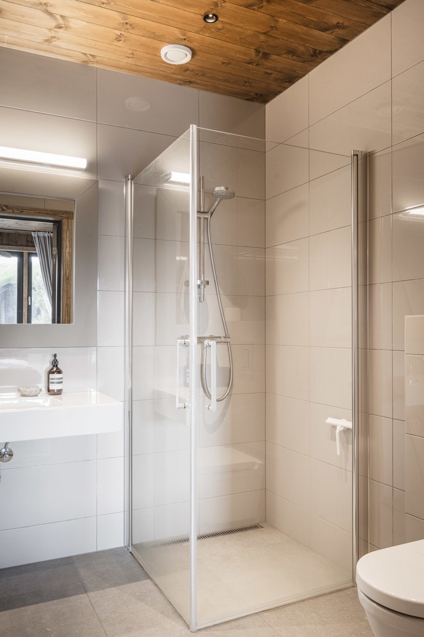 Badene har dusjhjørne med innadslående dører, servant, vegghengt wc og balansert ventilasjon. Galleribilde