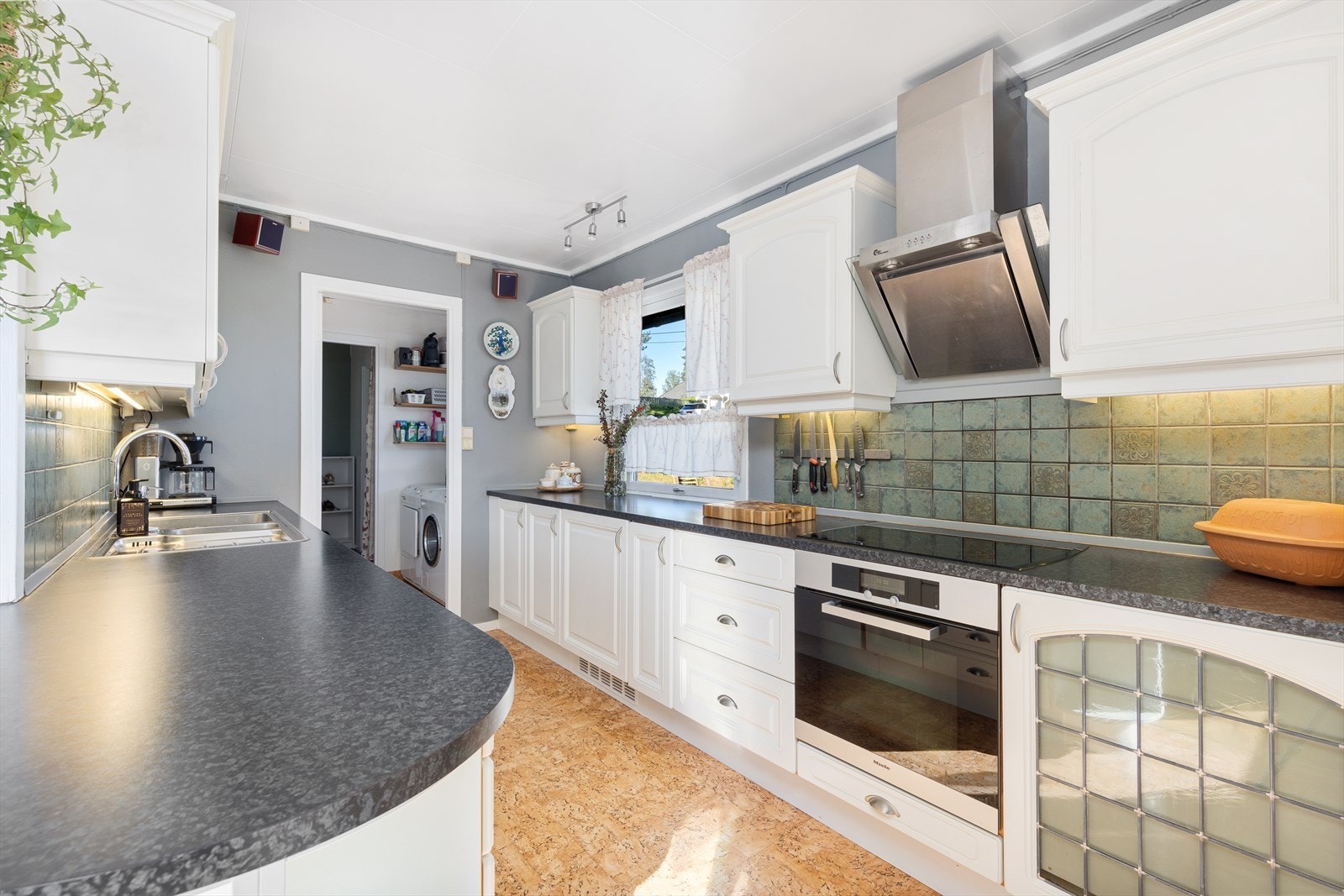 Kjøkkenet har innredning med profilerte fronter. Benkeplaten er av laminat. Galleribilde