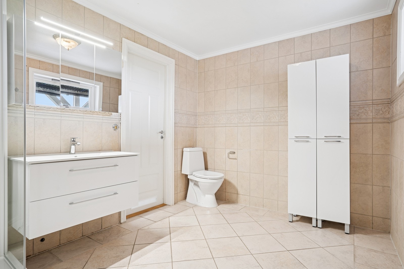 Romslig bad med muligheter for vaskemaskin og ekstra oppbevaring. Galleribilde