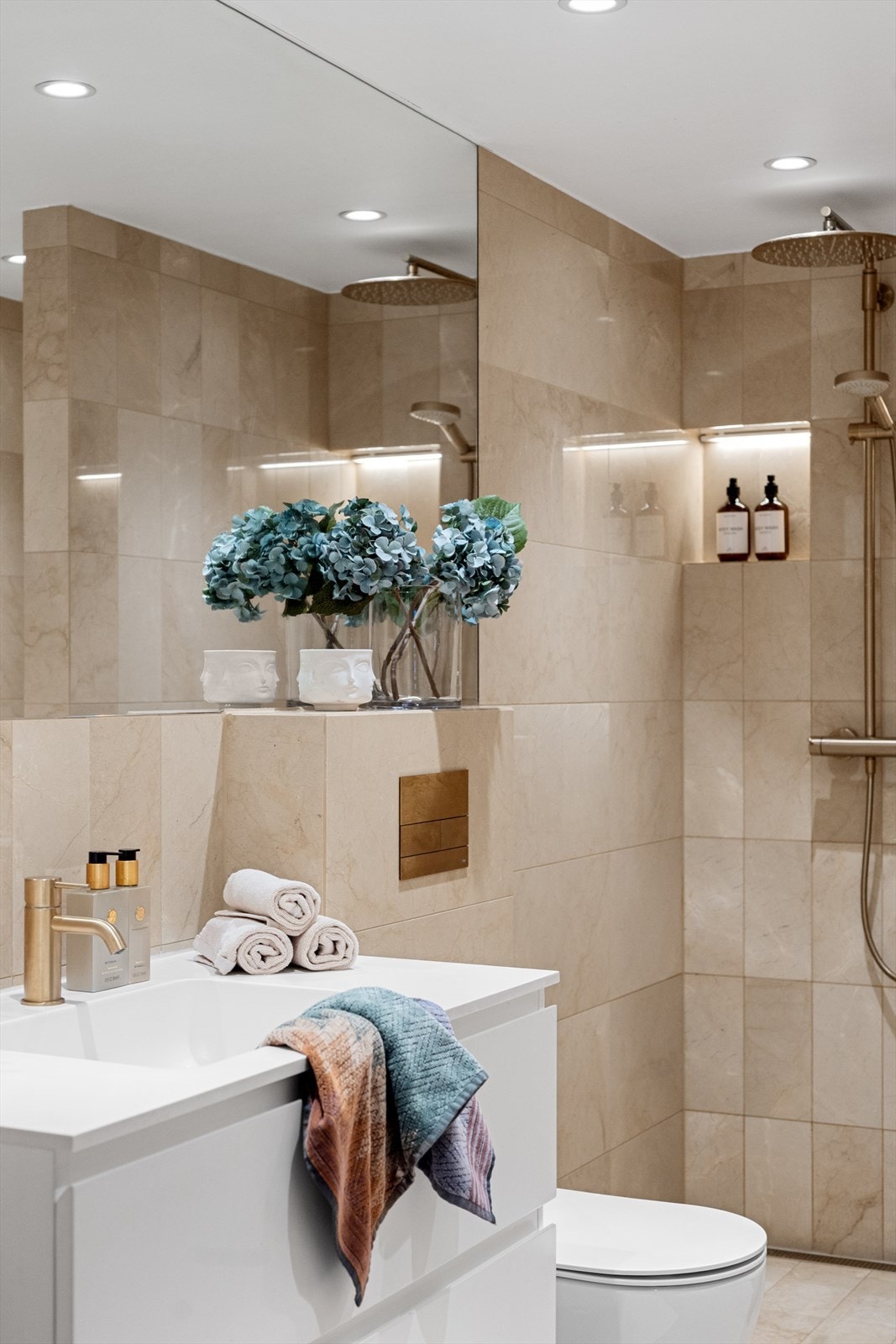 Her er det servant på benkeseksjon med underskuffer, speil, vegghengt toalett, høyskap og elektrisk håndkletørker. Galleribilde