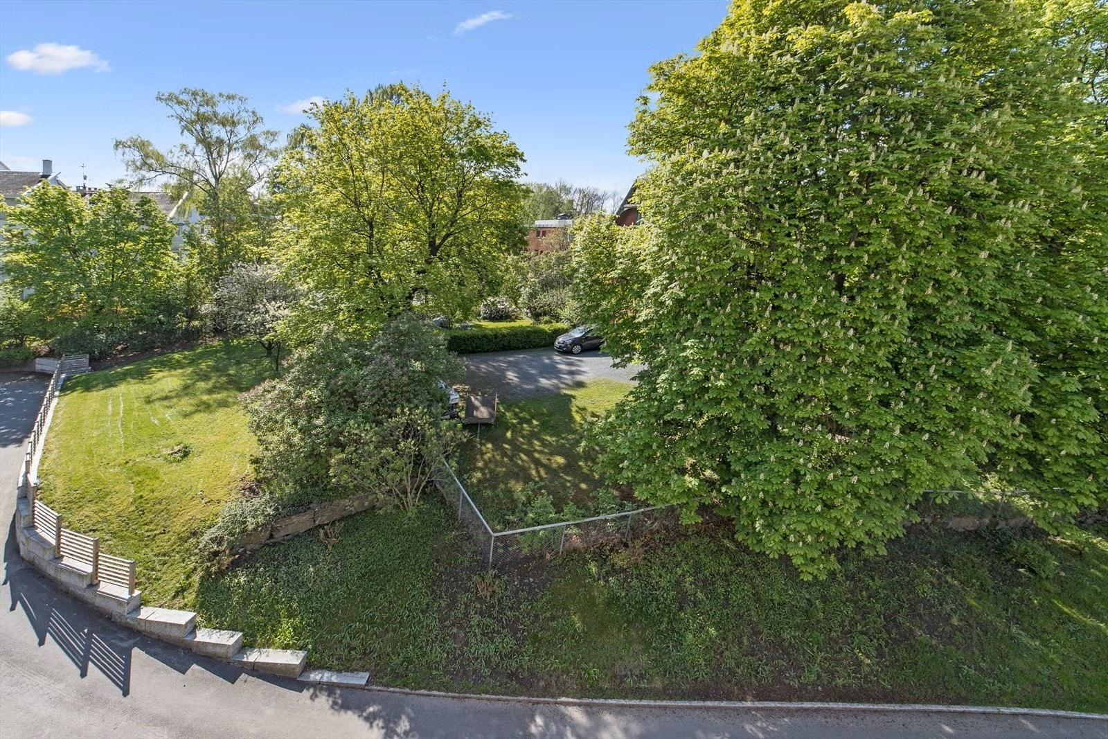 Utsikten fra terrassen mot en vakker villa dekket av en grønn drakt på sommerstid. Galleribilde