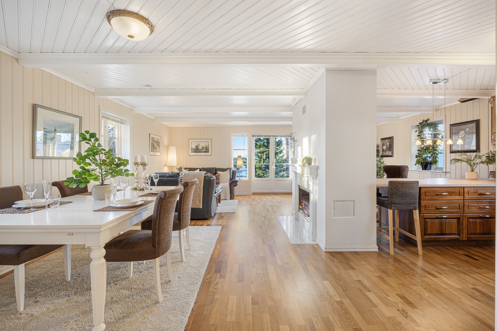 Rommet får rikelig med lys fra tre sider, og vinduene inkluderer en tofløyet glassdør til den vestvendte terrassen. Litt av det grønne slipper inn, og bidrar til en fin harmoni i rommet. Galleribilde