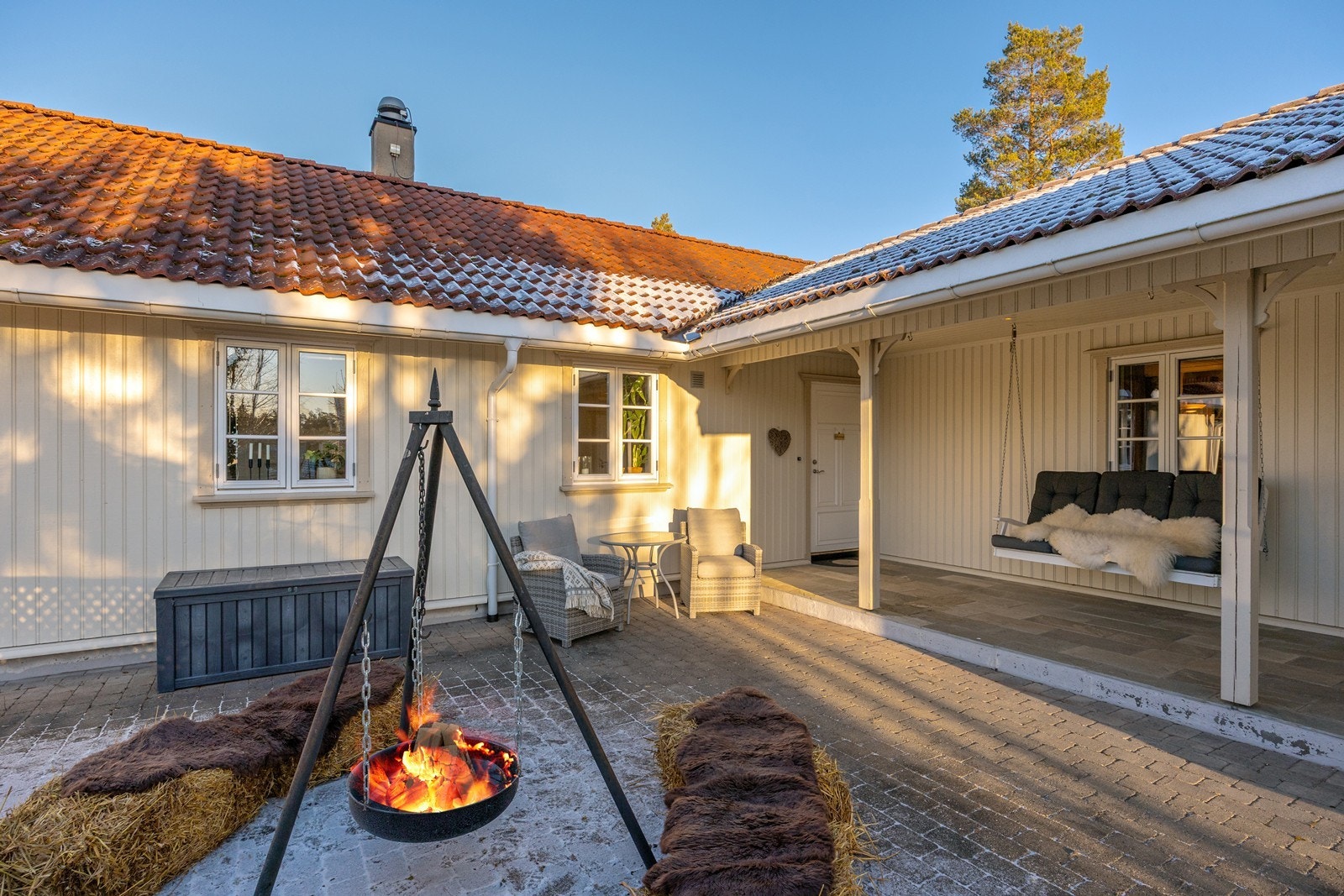 Svalgangen ved ytterdøren har plass til benker eller kafésett. Skiferhellene gir et stilrent uttrykk, og ved inngangen er en ringeklokke installert. Galleribilde