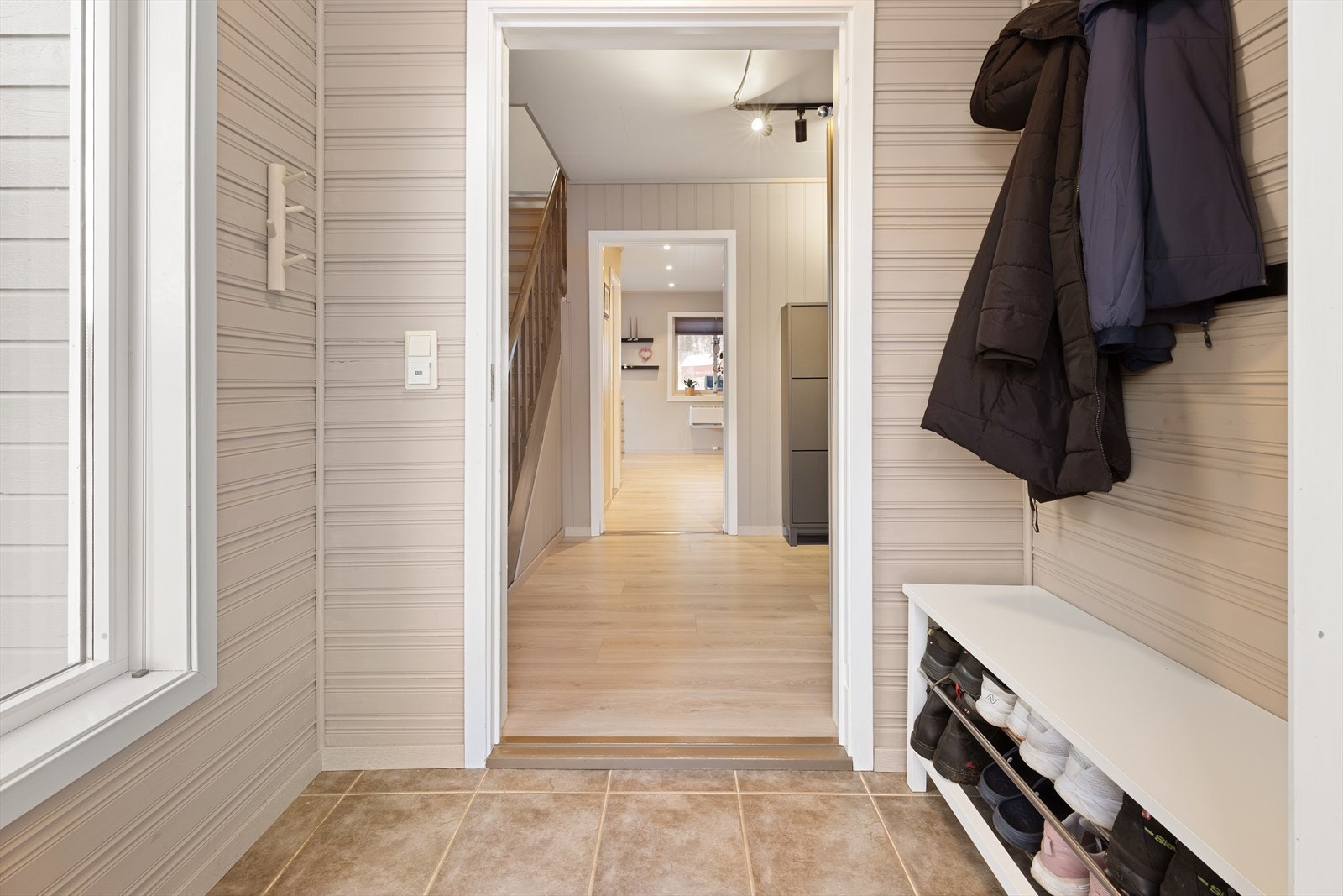 Lys og innbydende entré med flislagt gulv Galleribilde