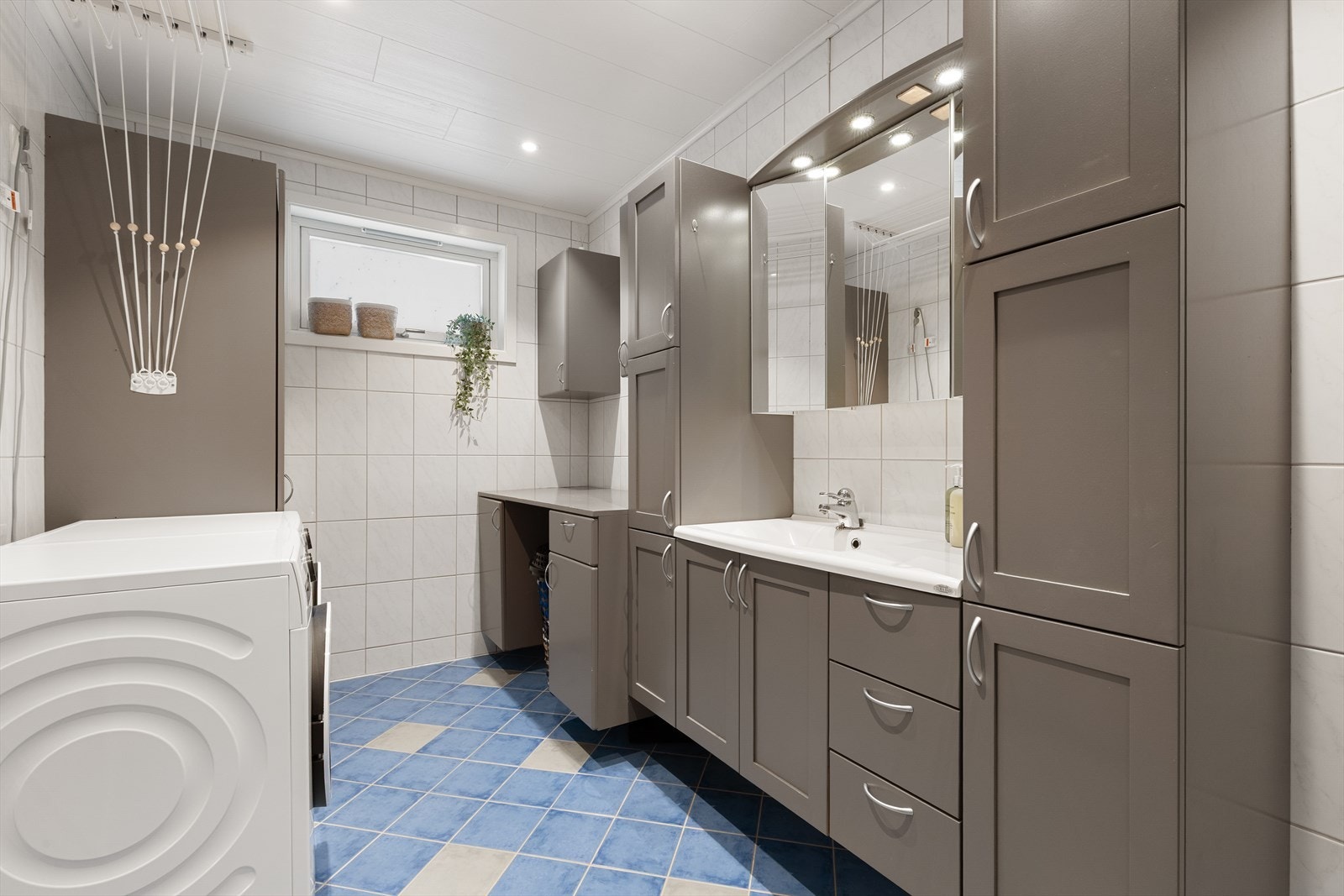 Innredning med servant med helstøpt platetopp, speildørsfronter i heltre og gode oppbevaringsløsninger Galleribilde