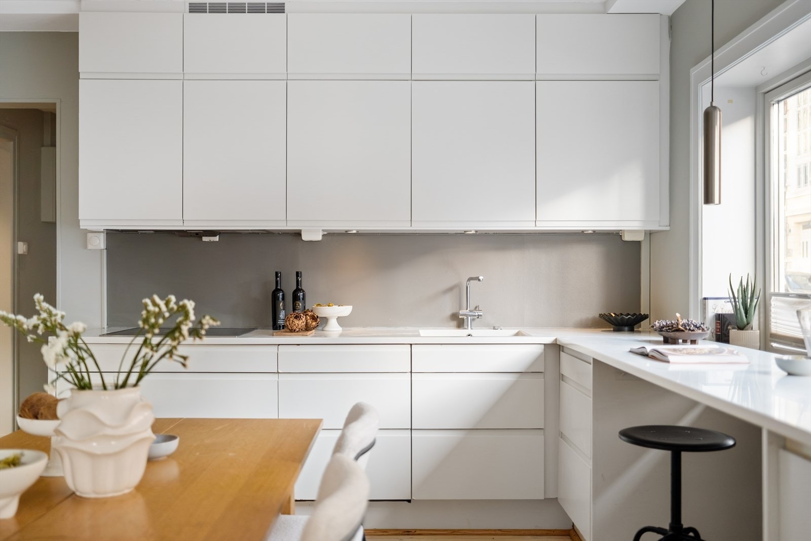 Kjøkkenet har glatte hvite fronter og lekker benkeplate i corian. Galleribilde