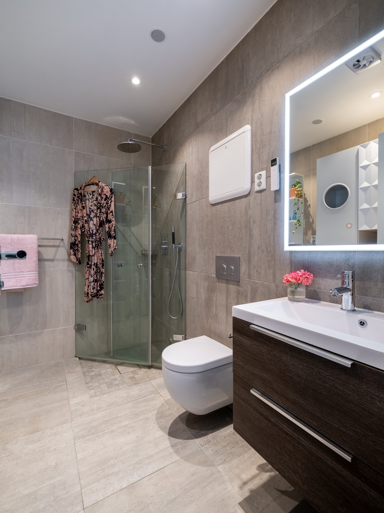 Badet er utstyrt med innredning med to skuffer og servant over, speil med belysning rundt, samt skap og hylle for oppbevaring. Galleribilde