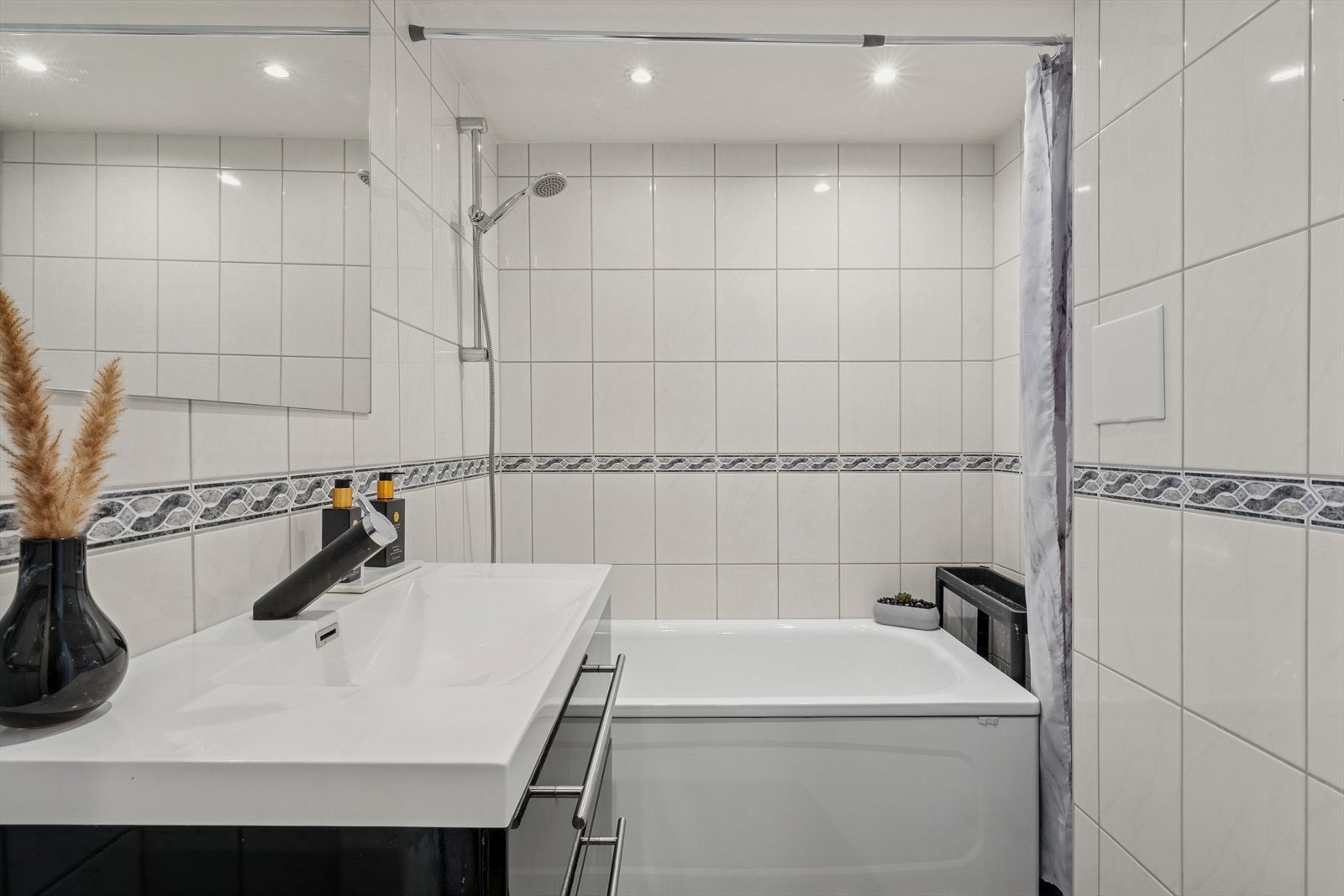 Baderom fra ca. 2010, oppgradert i regi av borettslaget, med flislagte overflater, elektriske varmekabler i gulv og innfelte downlights i himling. Galleribilde