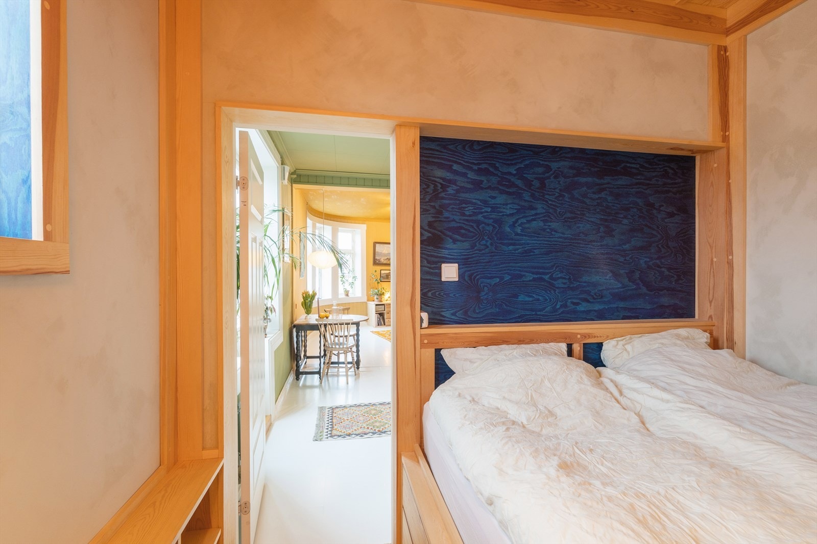 Soverommet har overflater med tregulv, malt teglsteinsvegg og malt, pusset overflate. Galleribilde