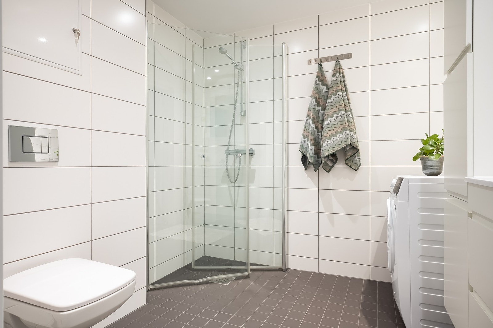 Stor og romslig dusj med innfellbare dører, samt vegghengt toalett. Galleribilde