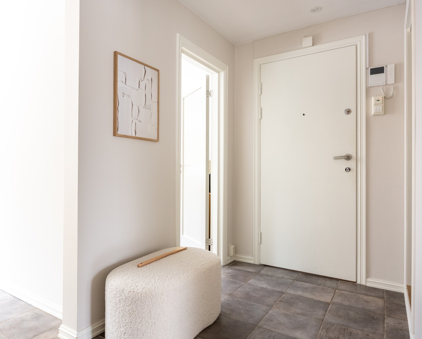 Lys entré med plass til oppheng av yttertøy og oppbevaring av sko. Galleribilde