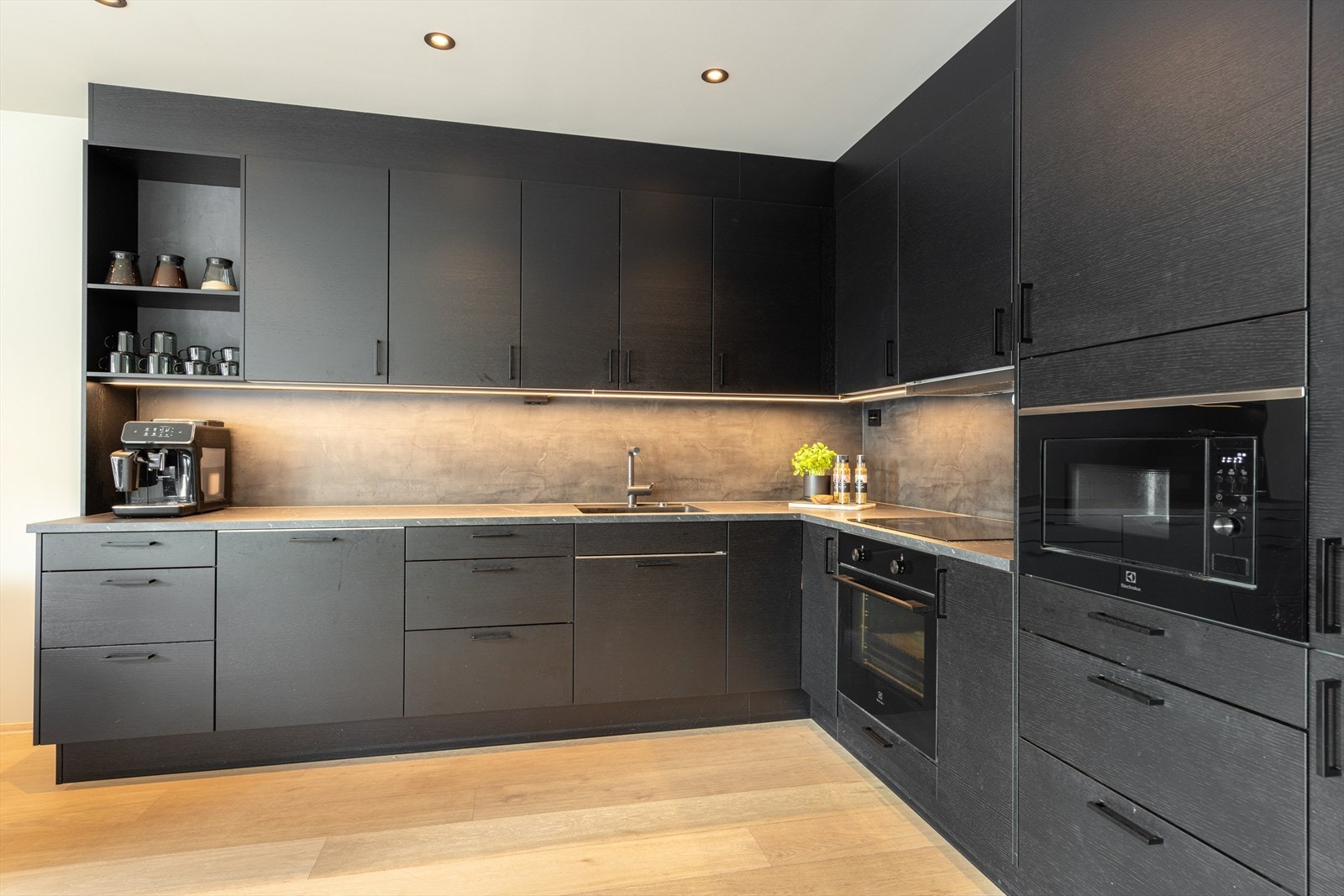 Øvrige integrerte hvitevarer er oppvaskmaskin, stekeovn og kjøl/fryseskap, samt mikro plassert i praktisk arbeidshøyde i høyskap. Over kokesonen er det ventilator. Komfyrvakt over koketopp og lekkasjevakt i benkeskap. Down-light belysning i tak. Galleribilde