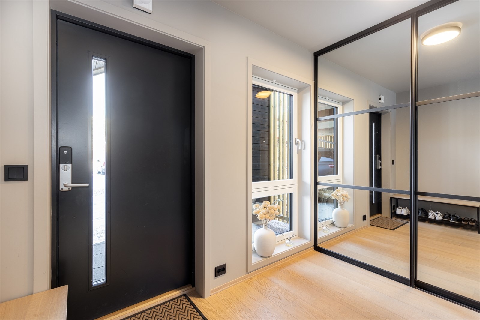 Boligen har et lyst og hyggelig inngangsparti med kodelås i inngangsdøren for enkel adkomst. Her er det god plass til sko- og ytterklær i skyvedørsgarderobe i moderne design. Galleribilde
