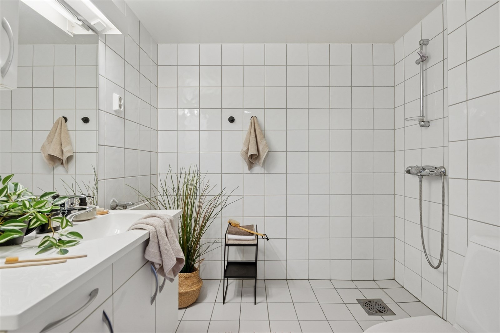 Badet er utstyrt med toalett, dusj, baderomsinnredning med nedfelt servant, samt opplegg for vaskemaskin. Galleribilde