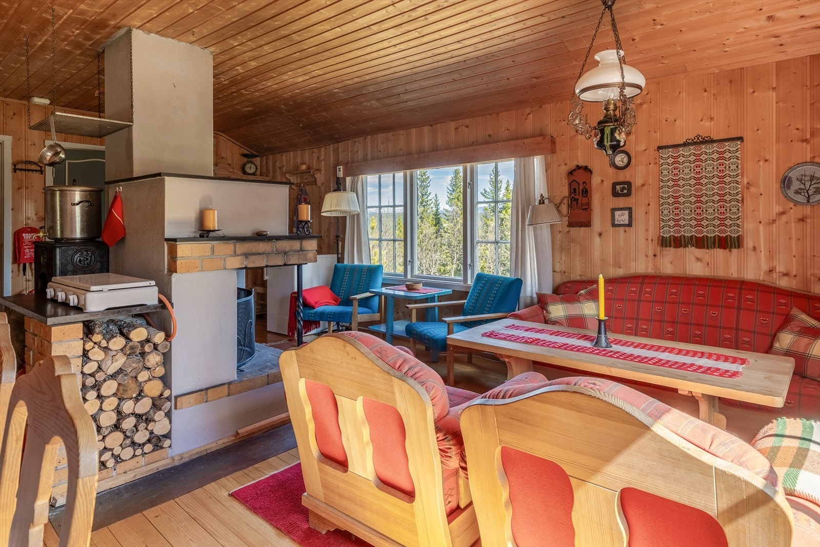 Vedovnen og den åpne peisen er plassert midt i rommet, og gir rommet en jevn og god varme. Galleribilde