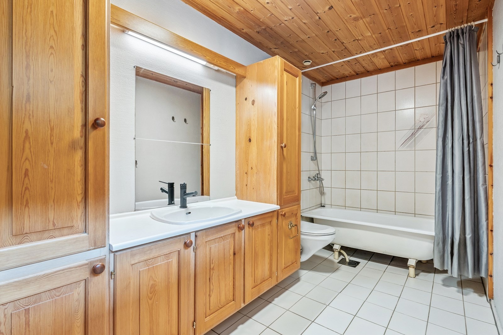 Badet har støpt gulv med varmekabler, og er utstyrt med frittstående badekar, toalett og en romslig servantinnredning med helstøpt servantplate og heltre fronter. Fliser i dusj/badekarområde. Galleribilde