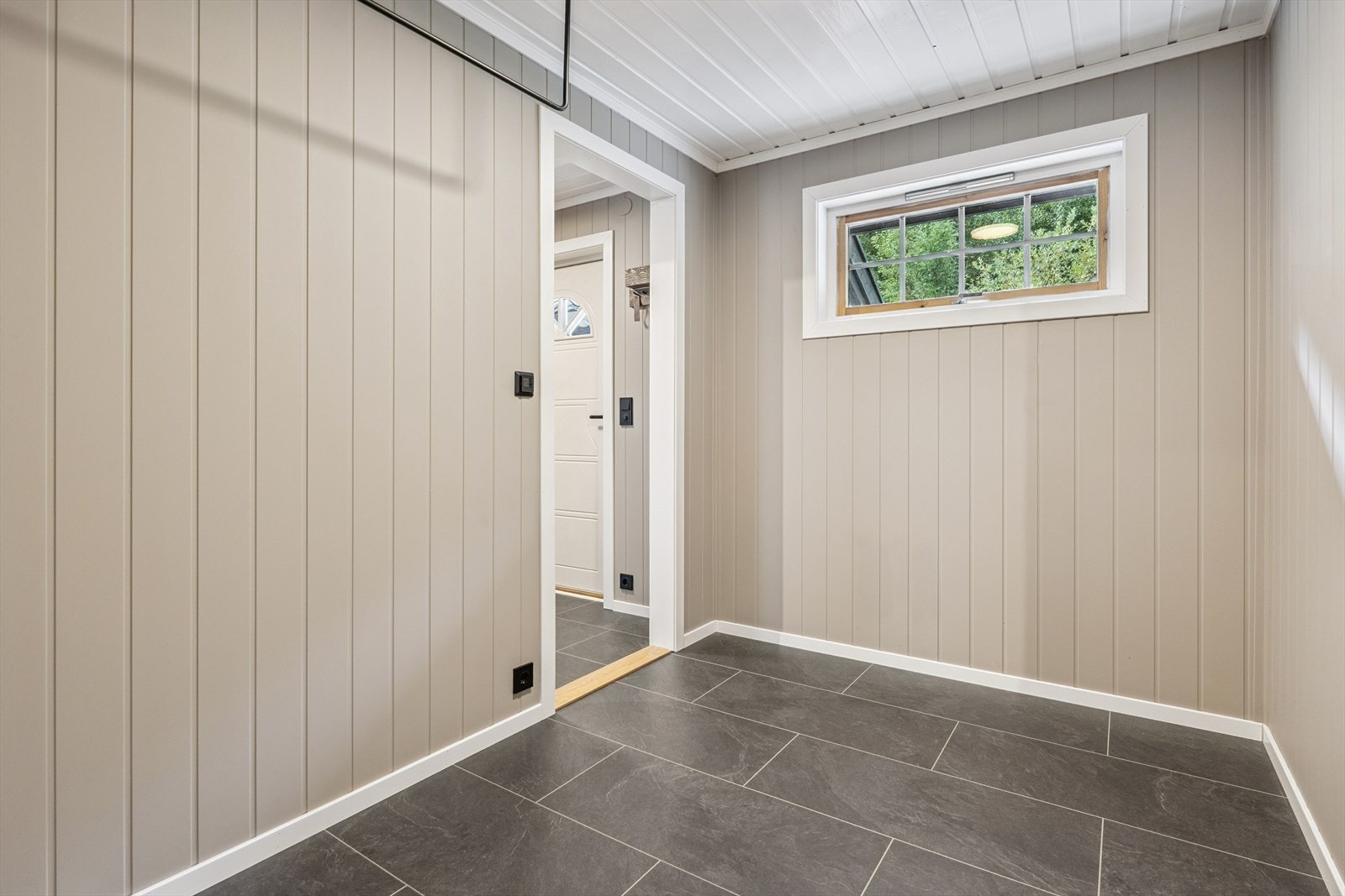 I entréen er det fliser med varmekabler, slik at sko og klær tørker raskt. Fra entréen kommer du videre inn til en større gang med mulighet for å lage gode garderobemuligheter. Galleribilde