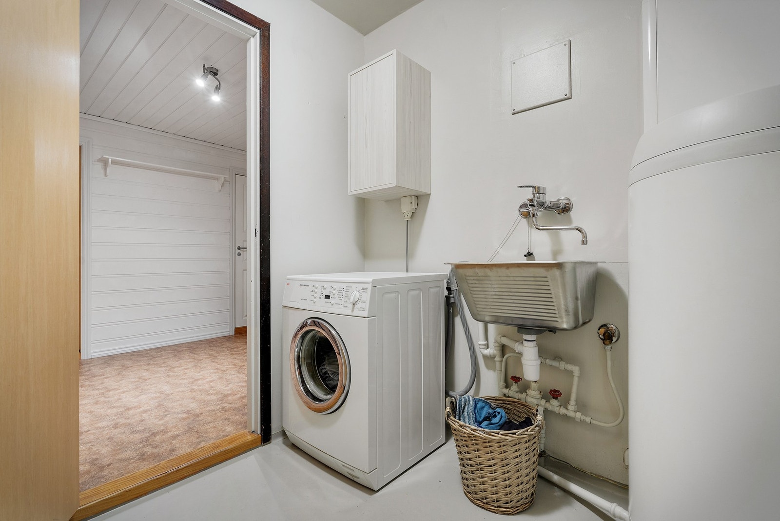 På vaskerommet er det malt våtromsbelegg på gulvet. Her er det innredet med utslagsvask, opplegg for vaskemaskin, varmtvannstank, rør i rør skap og avtrekksventil i vegg. Galleribilde