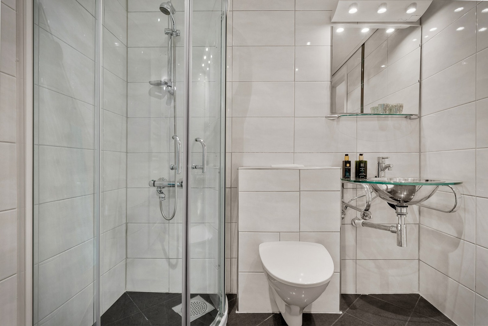 Badet ble modernisert i ca 2010 og inneholder servant, speil og belysning, vegghengt toalett, buet dusjhjørne i glass, dusjgarnityr. Galleribilde