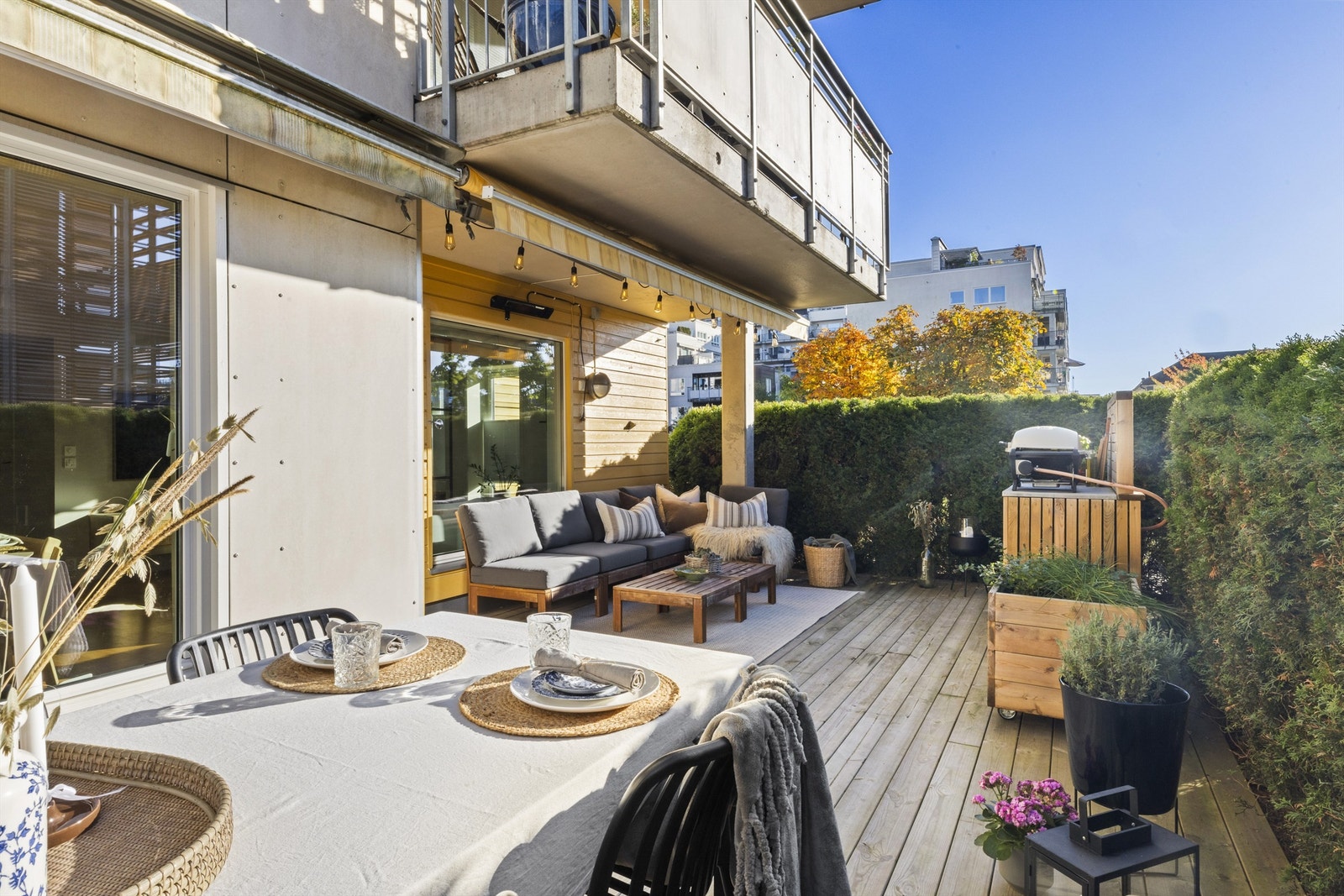 Markterrasse i trekonstruksjoner. Gulvflate er belagt med terrassebord. Terrassen har utebelysning, utvendige stikkontakter og markise Galleribilde