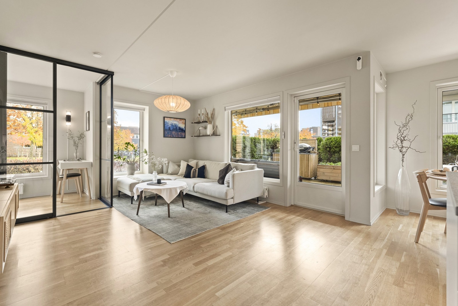 Lys stue med flere store vindusflater som slipper inn godt med lys Galleribilde