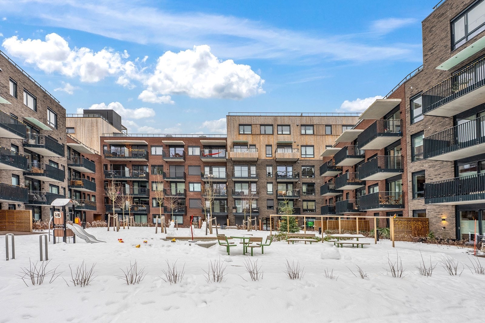 Leilighetskomplekset har felles uteområder med lekeplass og sittegrupper. Galleribilde