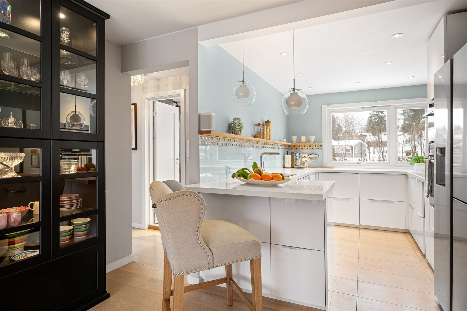 Kjøkkenet er innredet med hvite, glatte fronter og rikelig med skap- og benkeplass Galleribilde